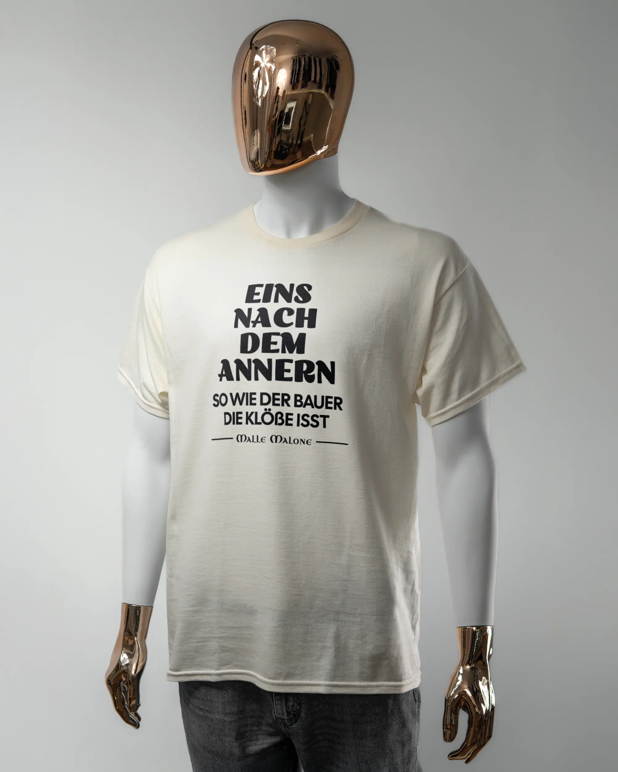 Vorderseite des Basic Unisex T-Shirt Regular von Maondo mit dem Design Eins nach dem Annern in der Farbe White und in der Größe L getragen von einer maskulinen Puppe