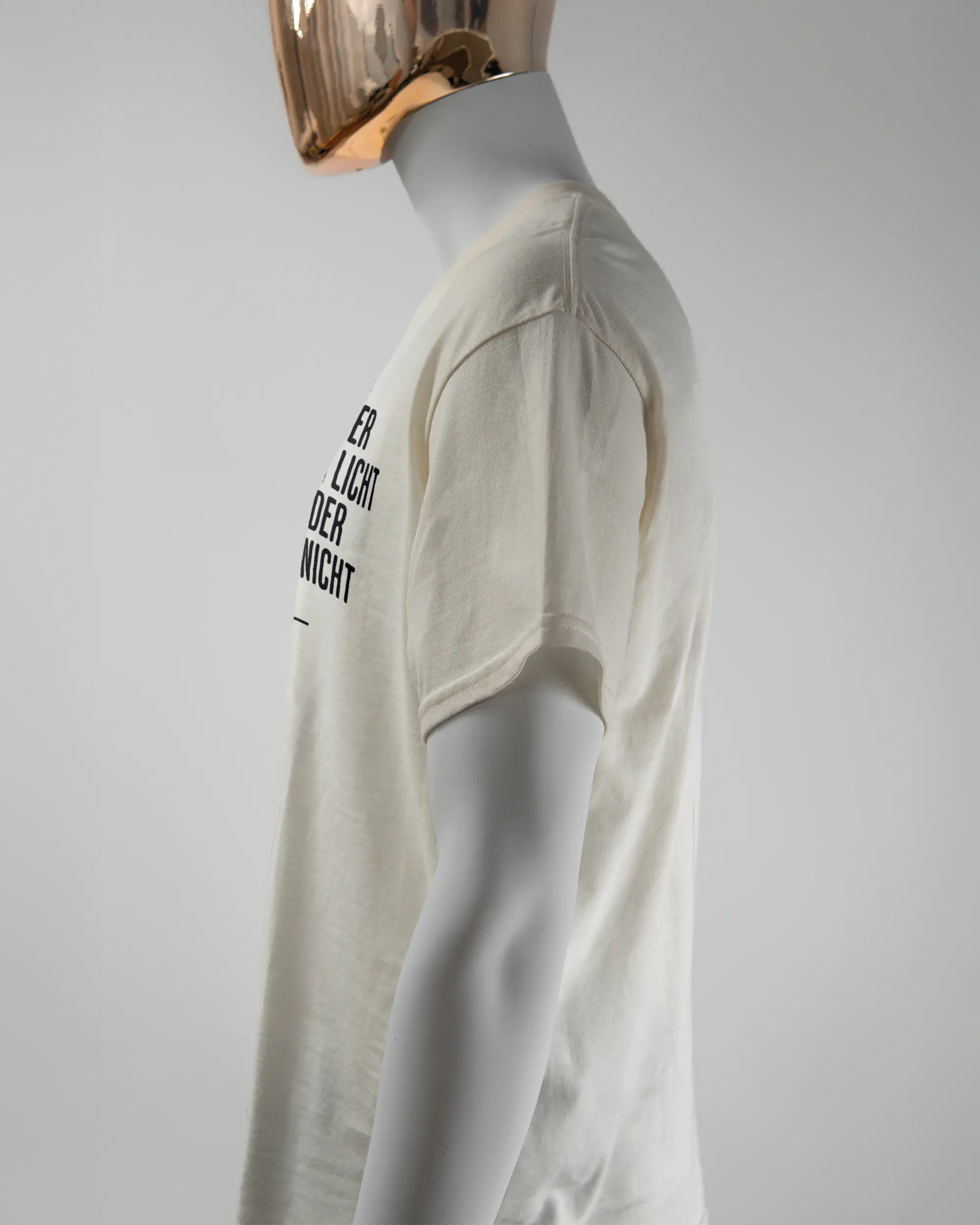 Seitenansicht des Basic Unisex T-Shirt Regular von Maondo mit dem Design Wegzeug vorne in der Farbe White und in der Größe L getragen von einer maskulinen Puppe