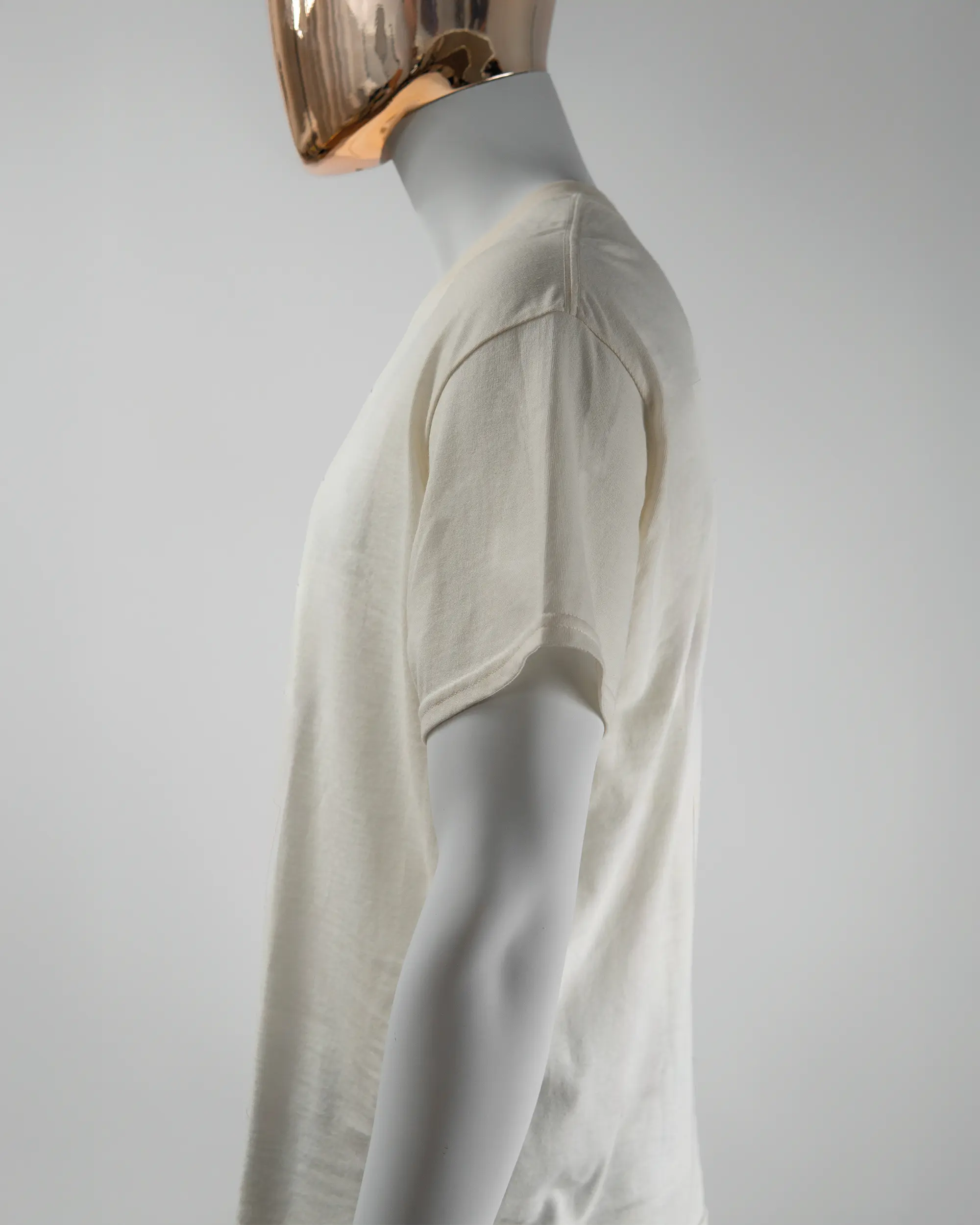 Seitenansicht des Basic Unisex T-Shirt Regular von Maondo mit dem Design Pigeon Pun vorne in der Farbe White und in der Größe L getragen von einer maskulinen Puppe