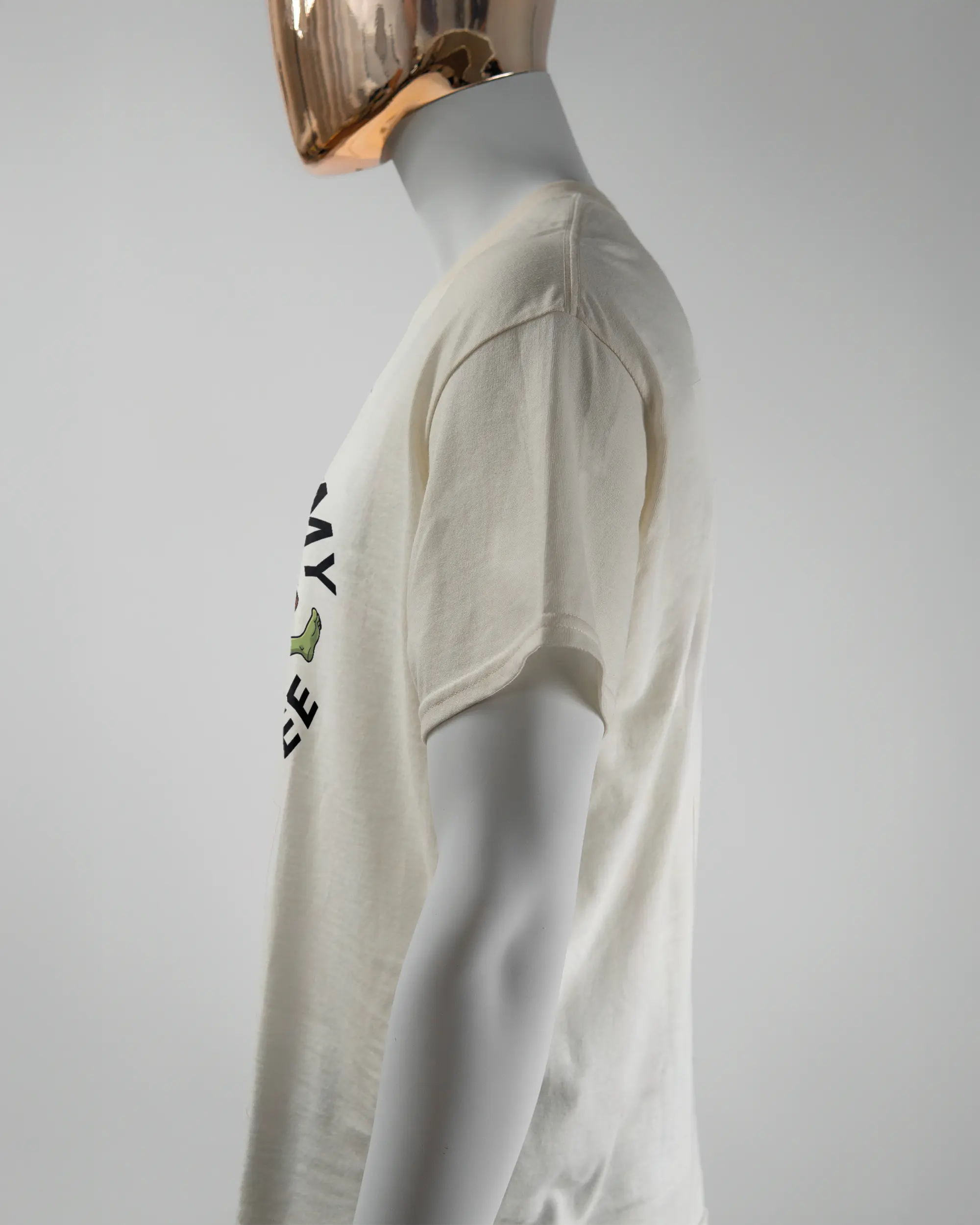 Seitenansicht des Basic Unisex T-Shirt Regular von Maondo mit dem Design Brocco-Lee vorne in der Farbe White und in der Größe L getragen von einer maskulinen Puppe