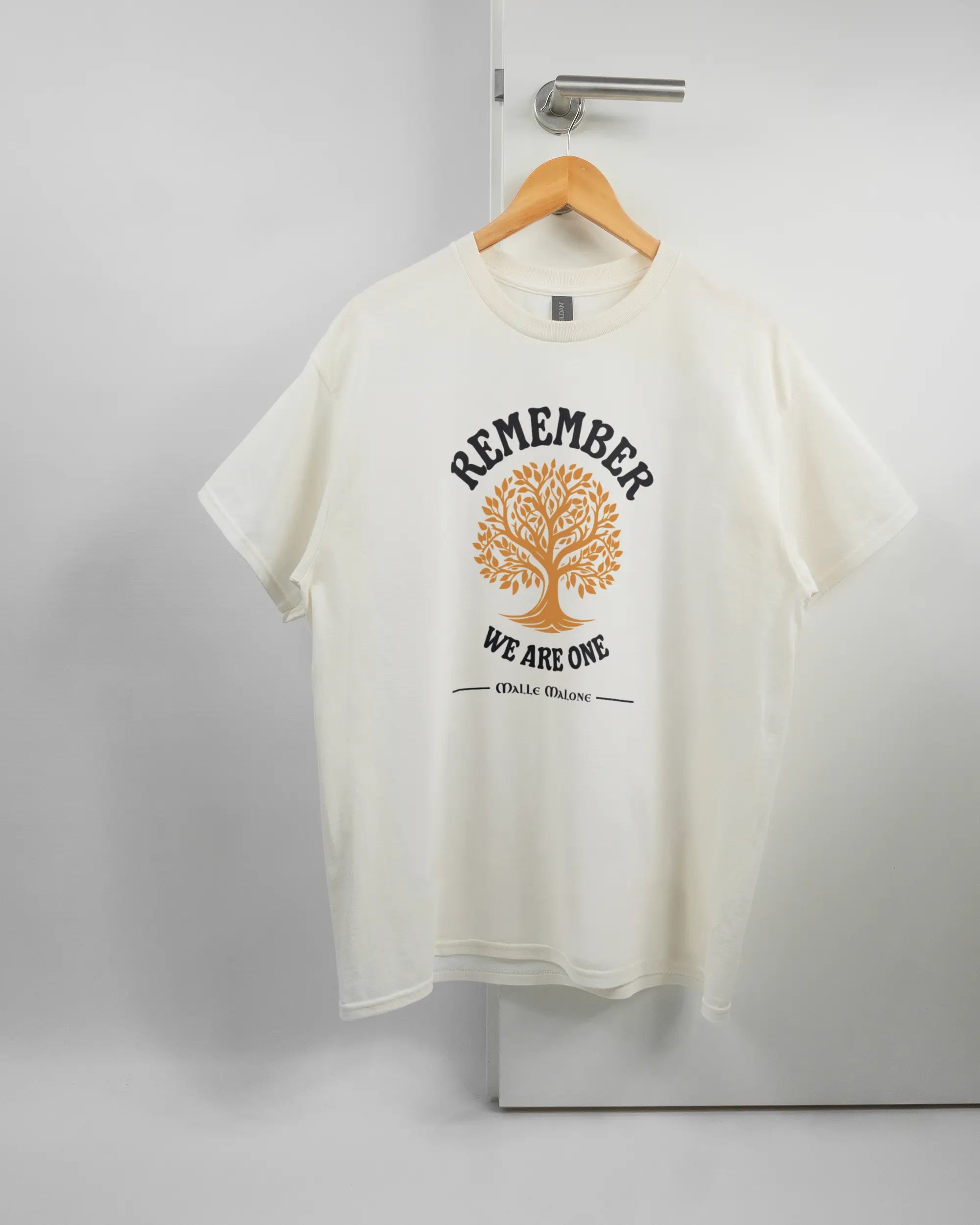 Vorderseite des Basic Unisex T-Shirt Regular von Maondo mit dem Design We are one in der Farbe White und in der Größe L auf einem Bügel an der Türklinke aufgehängt
