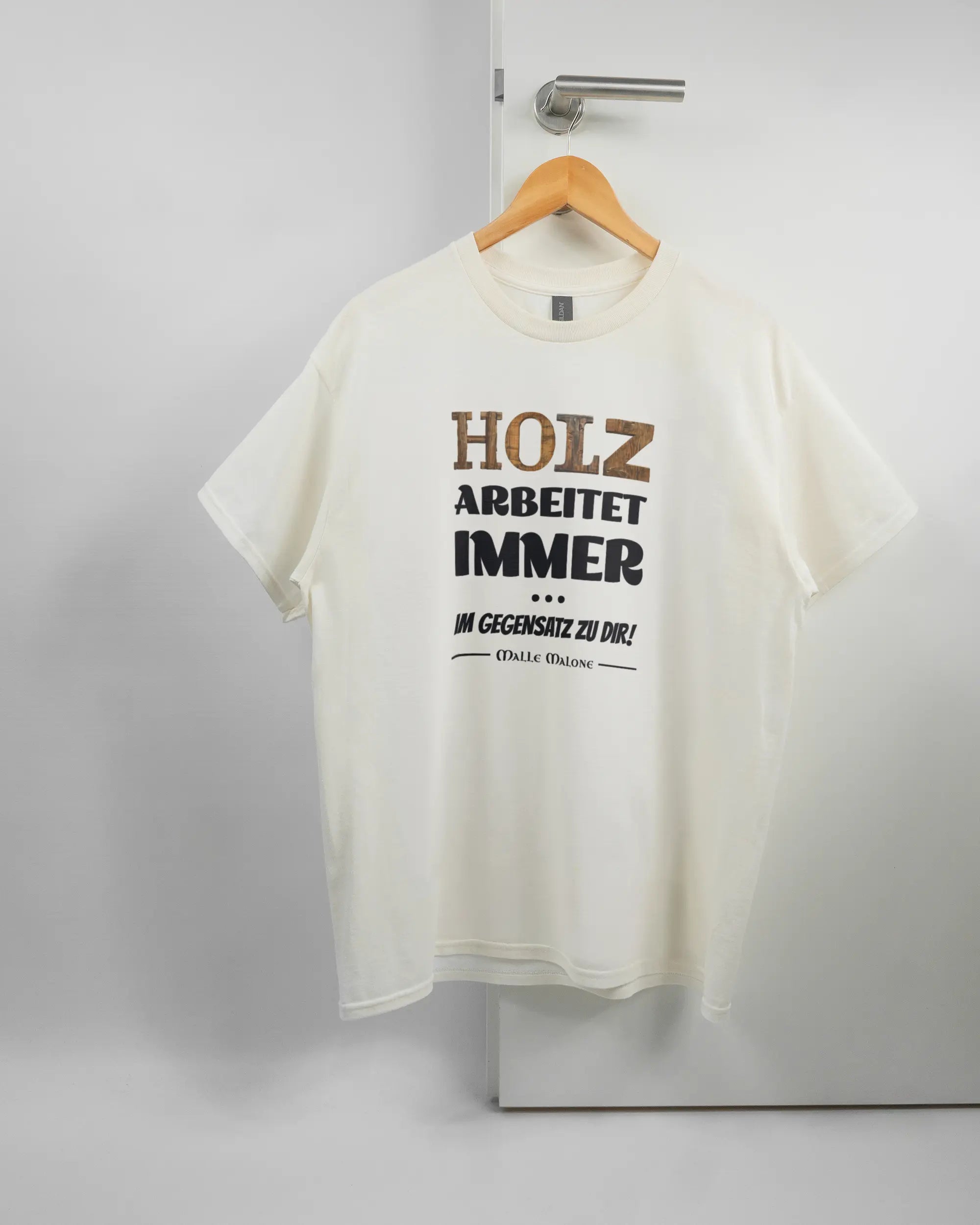 Vorderseite des Basic Unisex T-Shirt Regular von Maondo mit dem Design Holzarbeit in der Farbe White und in der Größe L auf einem Bügel an der Türklinke aufgehängt