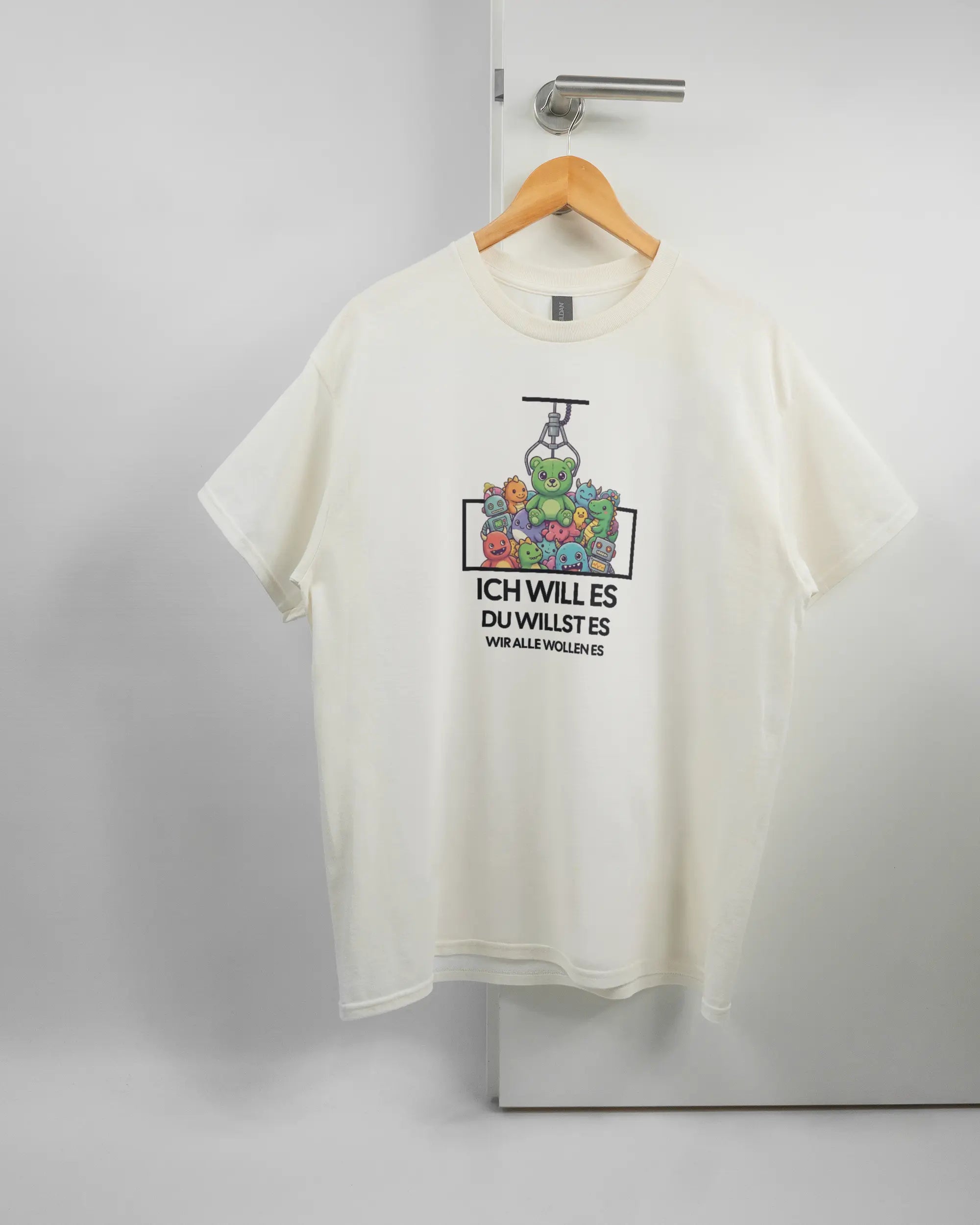 Vorderseite des Basic Unisex T-Shirt Regular von Maondo mit dem Design Will Stofftier in der Farbe White und in der Größe L auf einem Bügel an der Türklinke aufgehängt