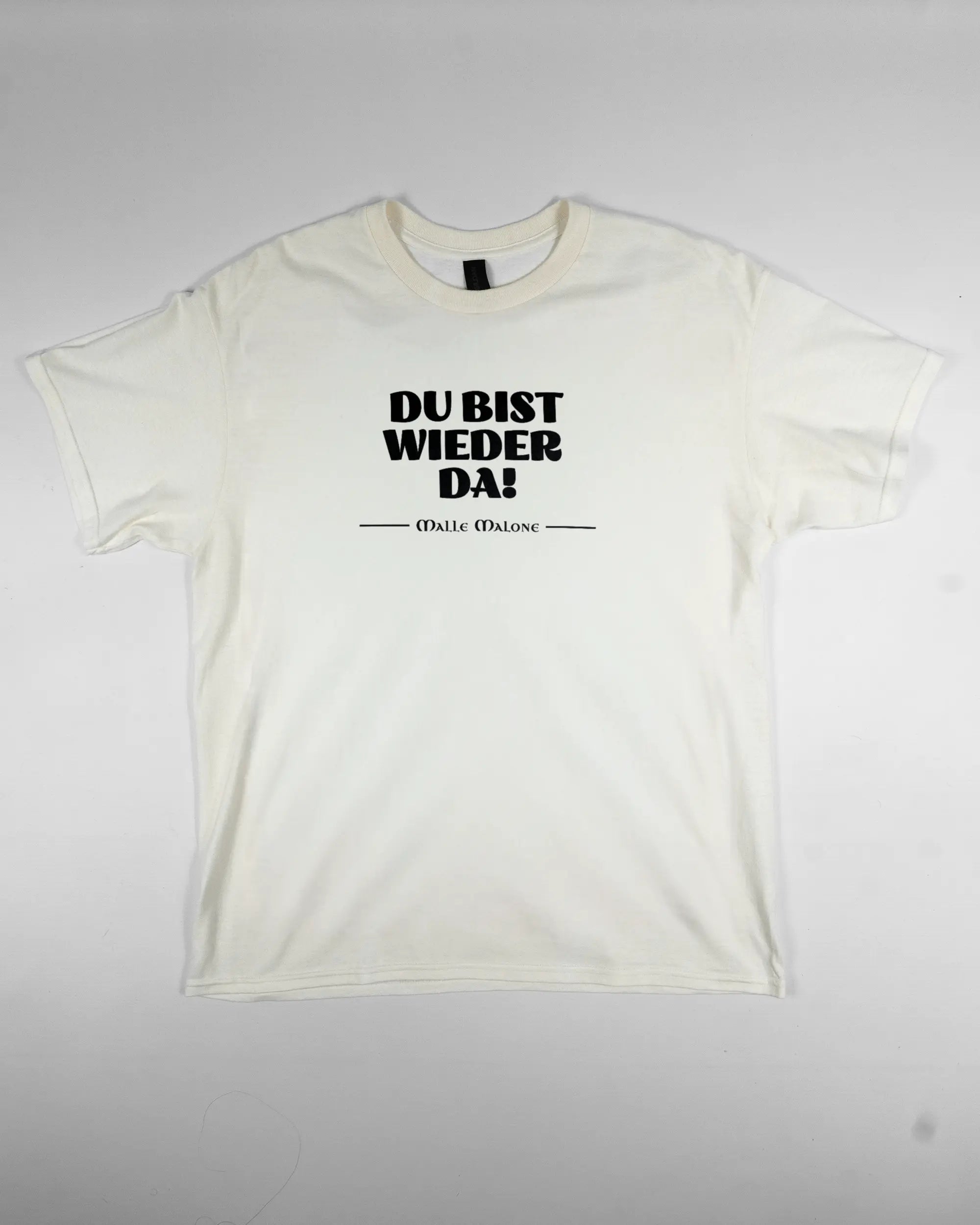 Vorderseite des Basic Unisex T-Shirt Regular von Maondo mit dem Design Wieder da in der Farbe White und in der Größe L flach auf den Boden gelegt