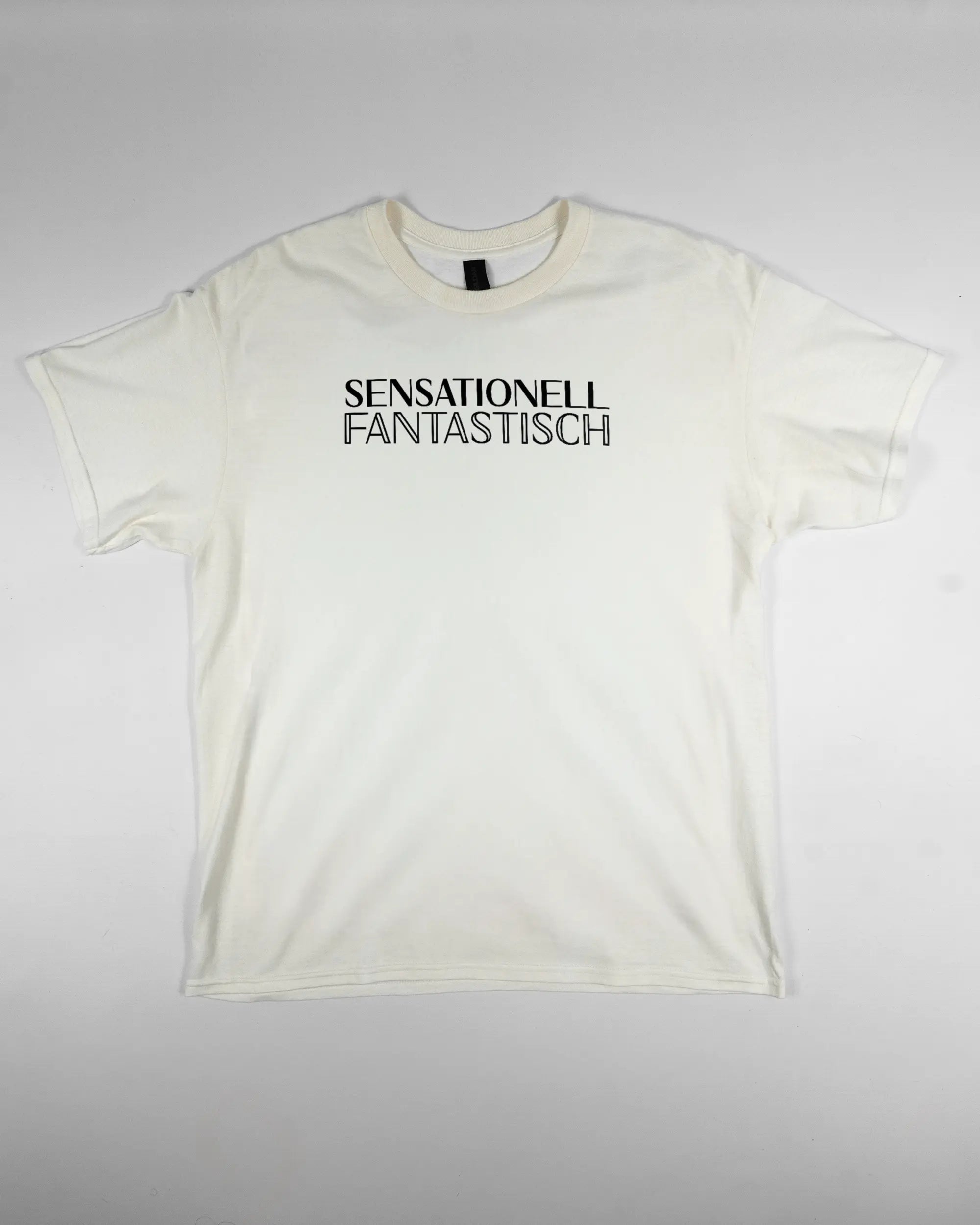 Vorderseite des Basic Unisex T-Shirt Regular von Maondo mit dem Design Sensationell in der Farbe White und in der Größe L flach auf den Boden gelegt