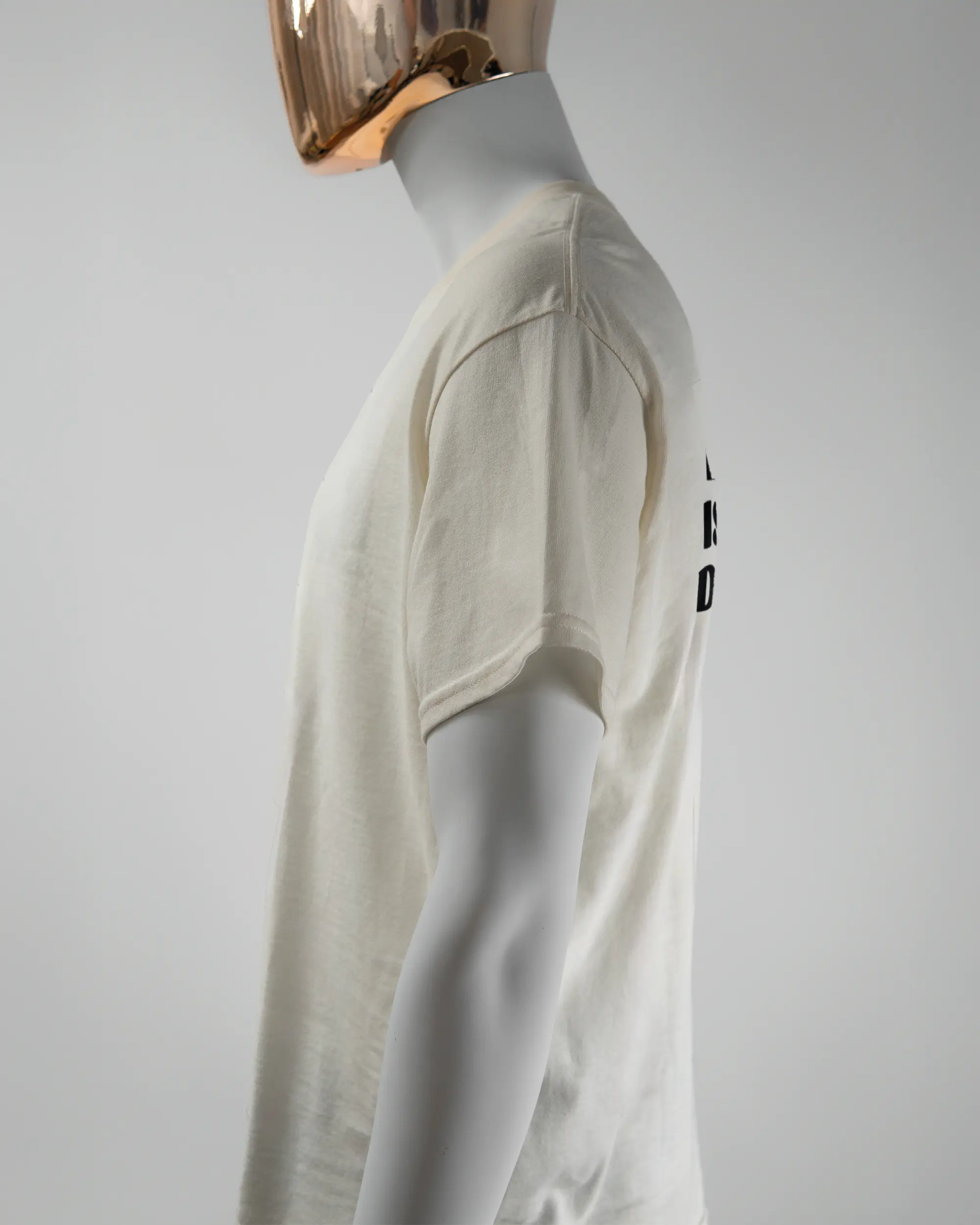 Seitenansicht des Basic Unisex T-Shirt Regular von Maondo mit dem Design Keine Eile hinten in der Farbe White und in der Größe L getragen von einer maskulinen Puppe