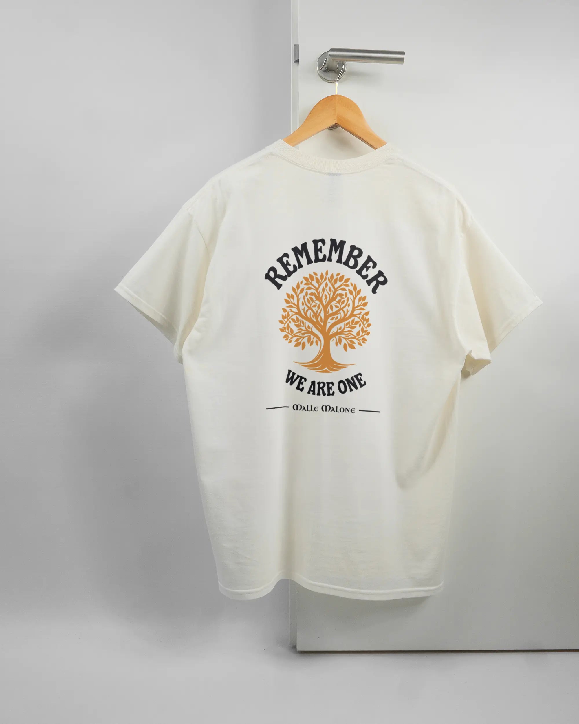 Rückseite des Basic Unisex T-Shirt Regular von Maondo mit dem Design We are one in der Farbe White und in der Größe L auf einem Bügel an der Türklinke aufgehängt