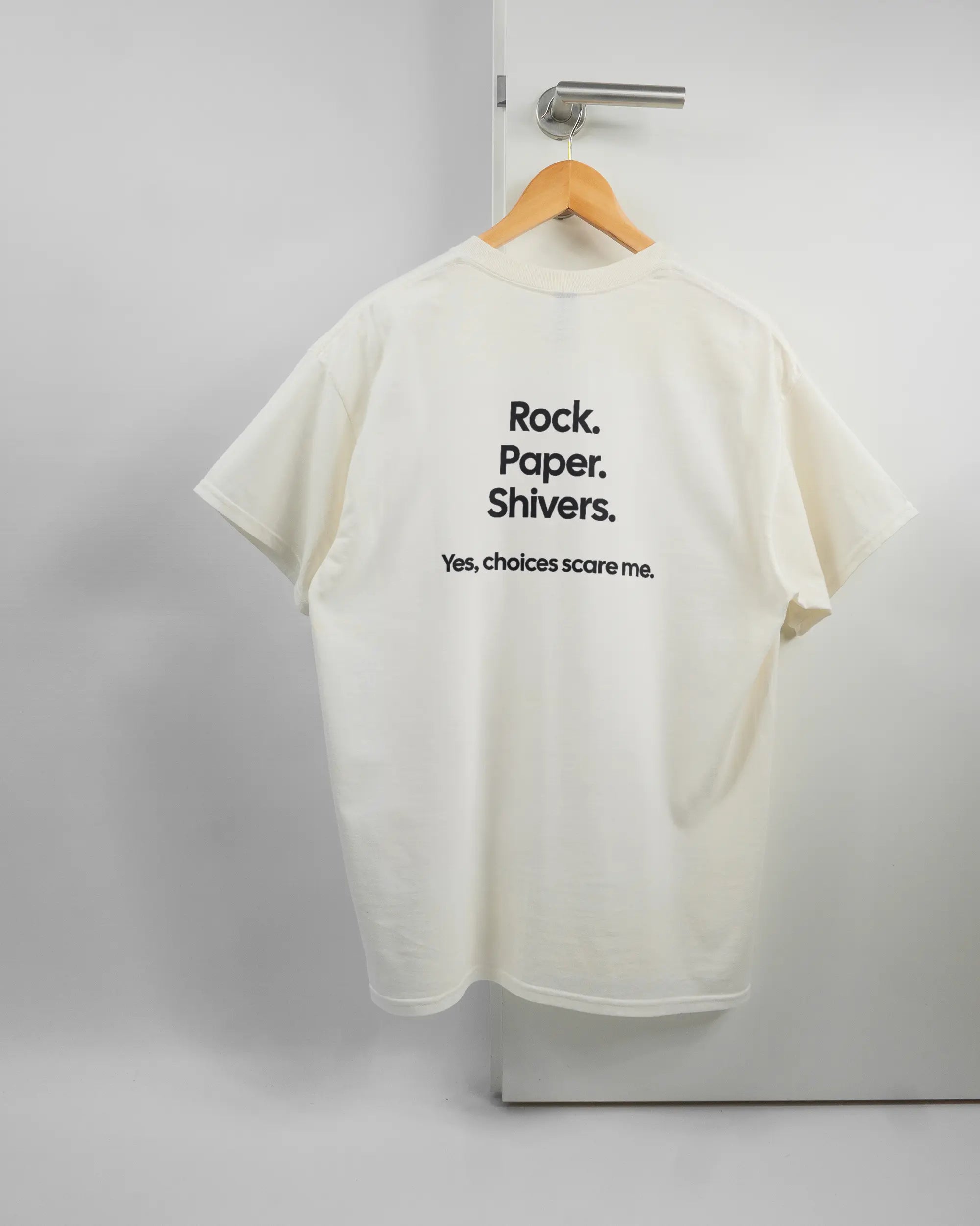 Rückseite des Basic Unisex T-Shirt Regular von Maondo mit dem Design Rock Paper Shivers in der Farbe White und in der Größe L auf einem Bügel an der Türklinke aufgehängt
