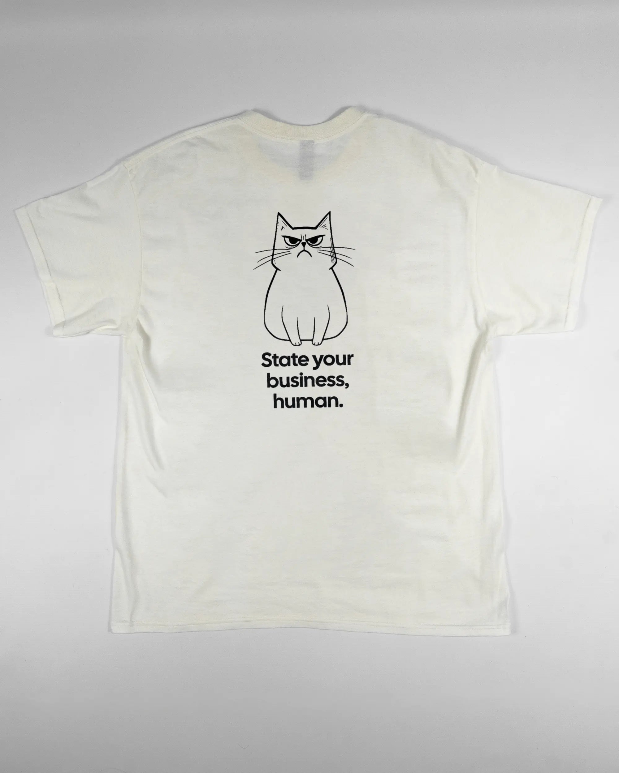 Rückseite des Basic Unisex T-Shirt Regular von Maondo mit dem Design Grumpy Purr in der Farbe White und in der Größe L flach auf den Boden gelegt