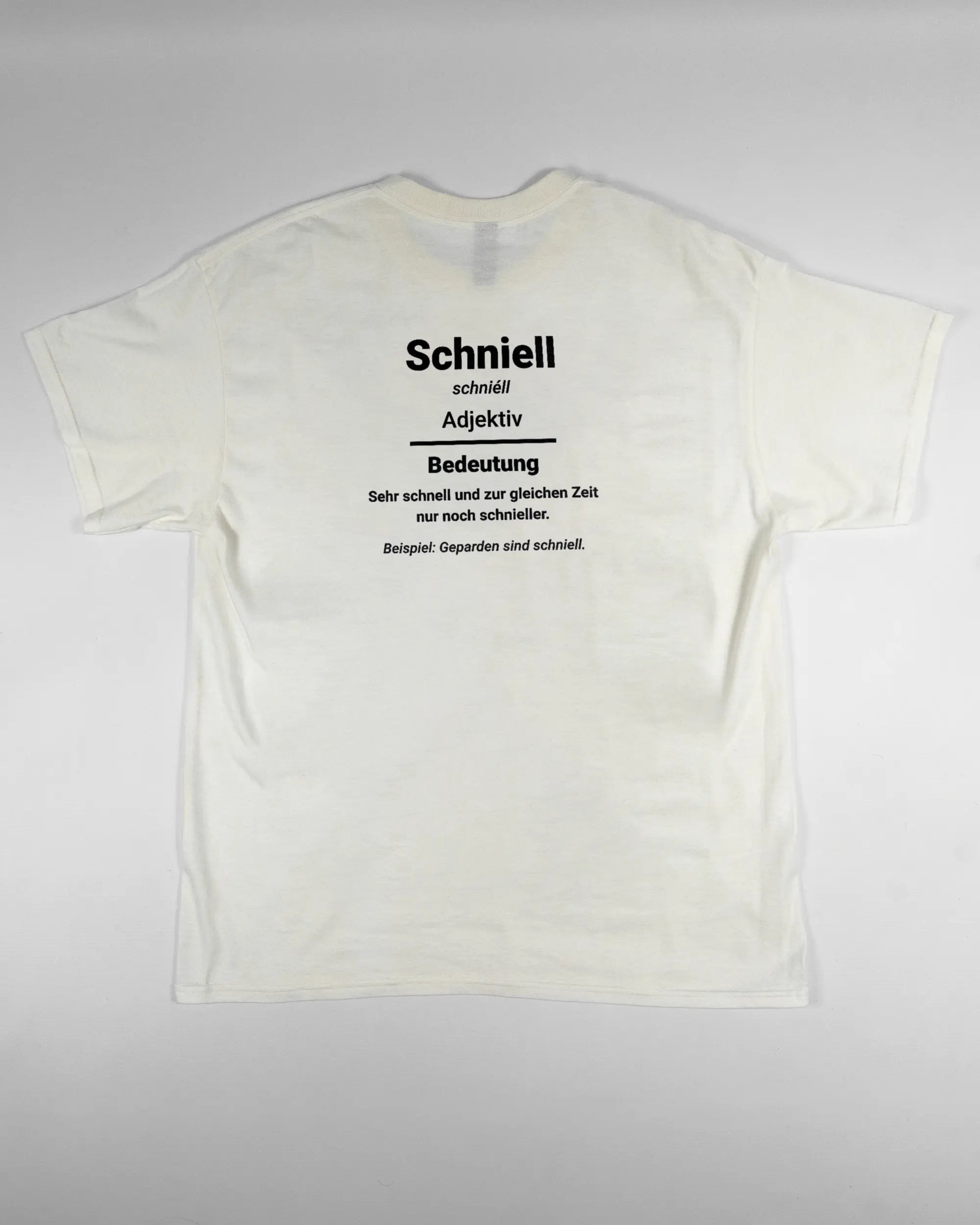 Rückseite des Basic Unisex T-Shirt Regular von Maondo mit dem Design Schniell in der Farbe White und in der Größe L flach auf den Boden gelegt