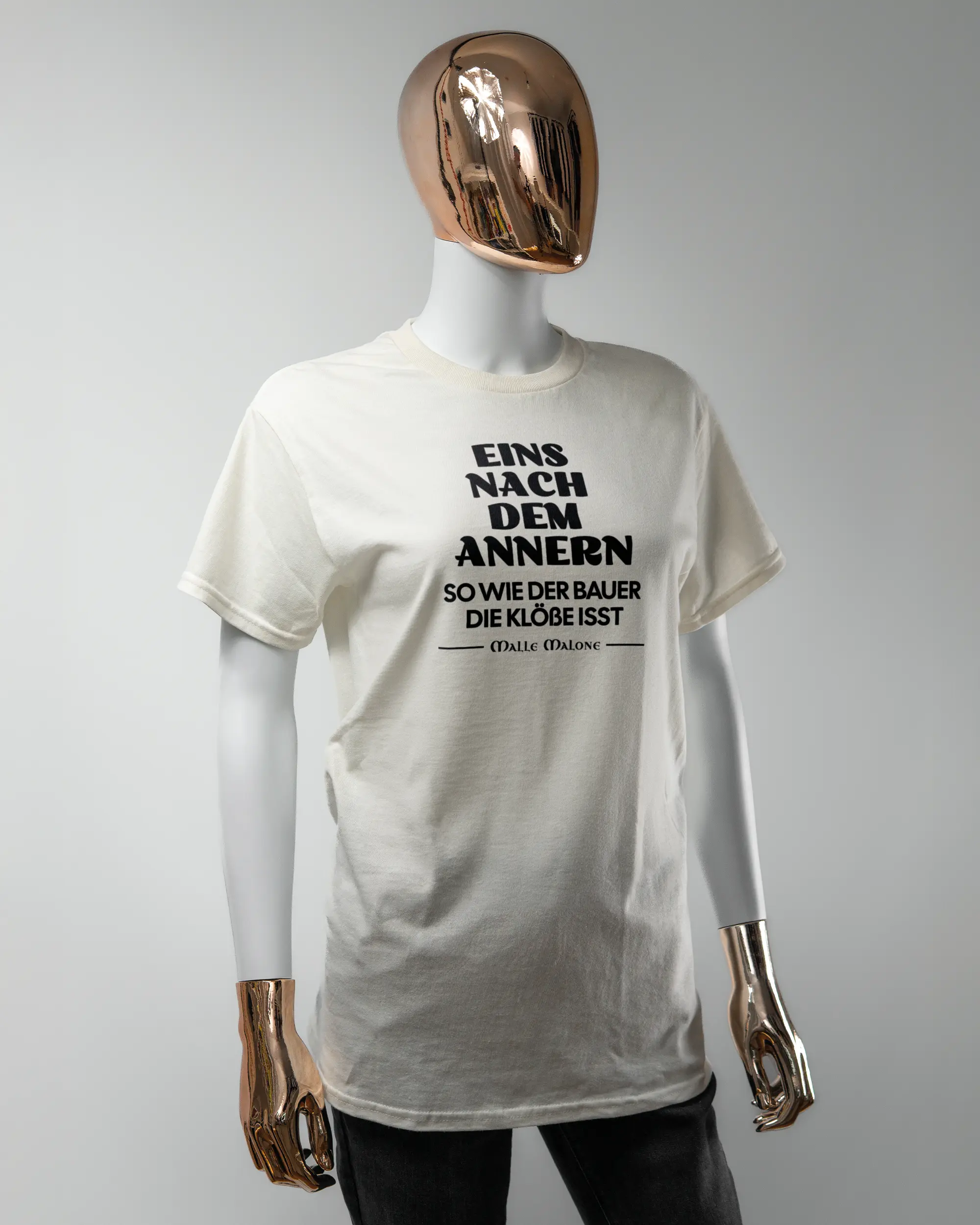 Vorderseite des Basic Unisex T-Shirt Regular von Maondo mit dem Design Eins nach dem Annern in der Farbe White und in der Größe S getragen von einer femininen Puppe