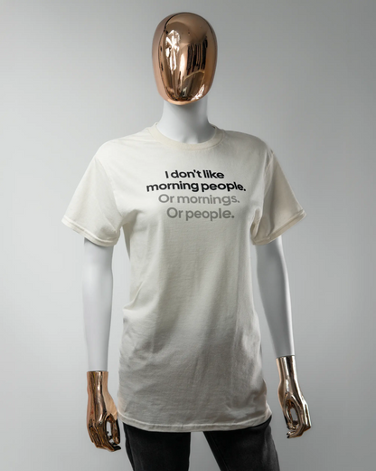 Vorderseite des Basic Unisex T-Shirt Regular von Maondo mit dem Design Morning Person in der Farbe White und in der Größe S getragen von einer femininen Puppe