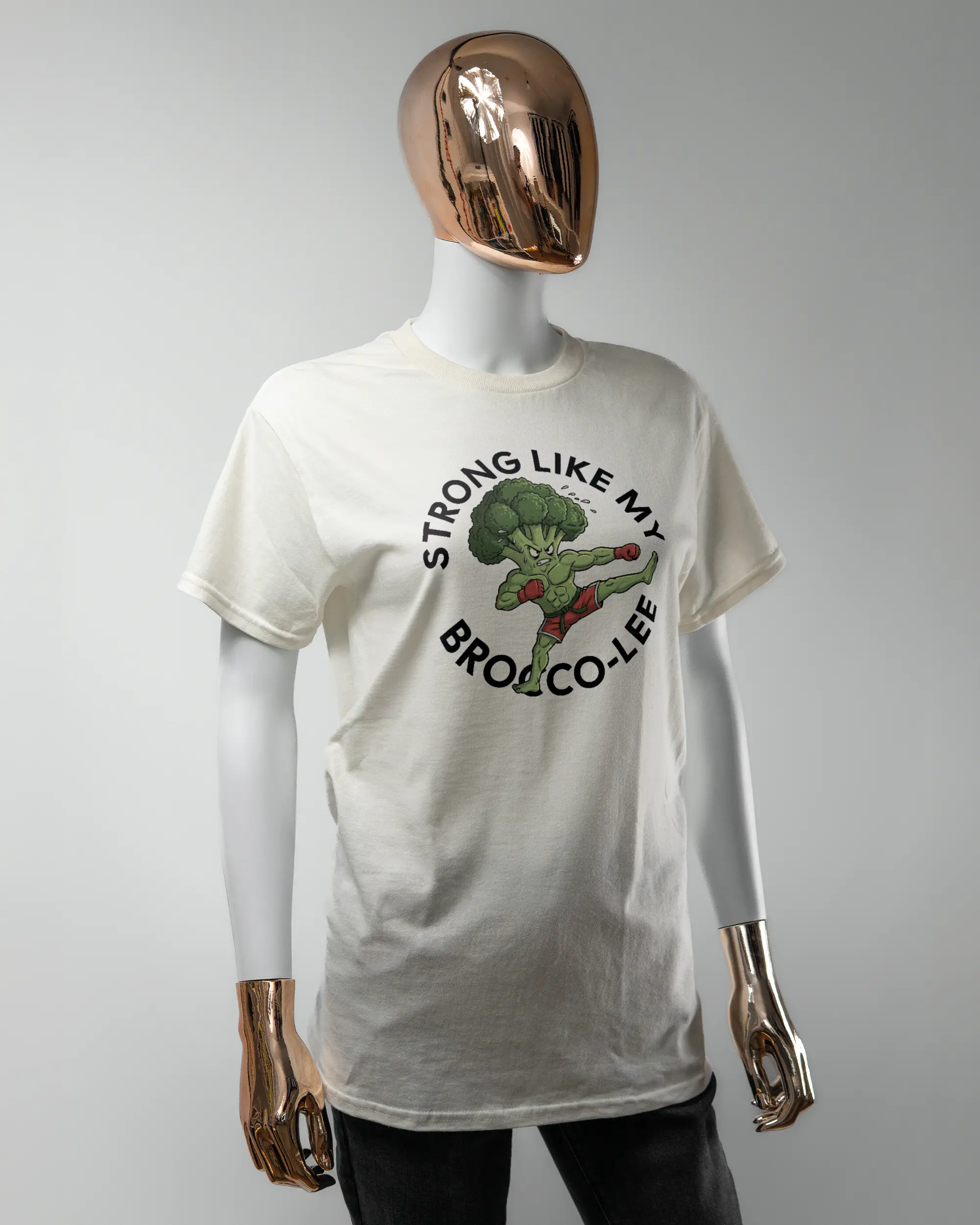 Vorderseite des Basic Unisex T-Shirt Regular von Maondo mit dem Design Brocco-Lee in der Farbe White und in der Größe S getragen von einer femininen Puppe