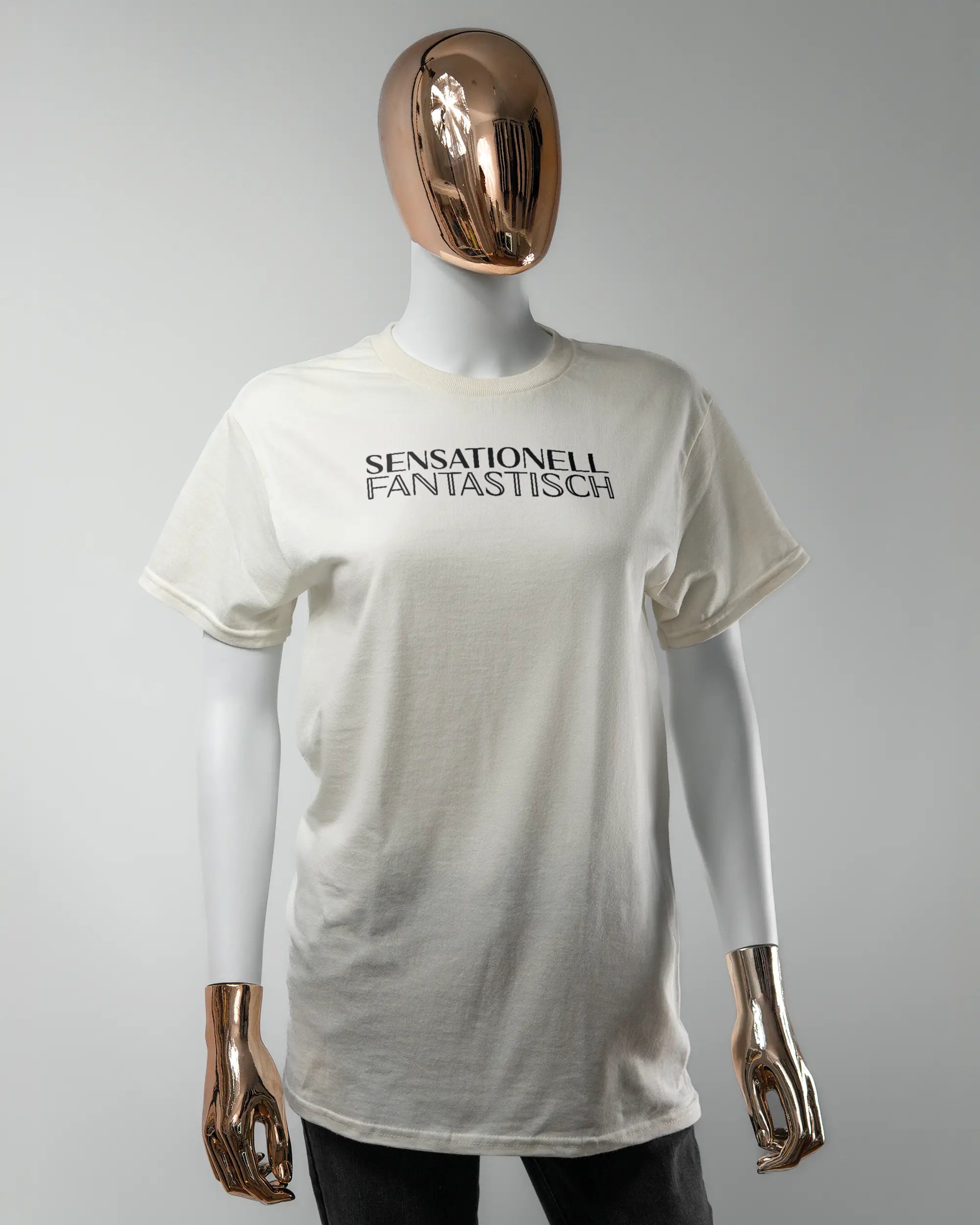 Vorderseite des Basic Unisex T-Shirt Regular von Maondo mit dem Design Sensationell in der Farbe White und in der Größe S getragen von einer femininen Puppe