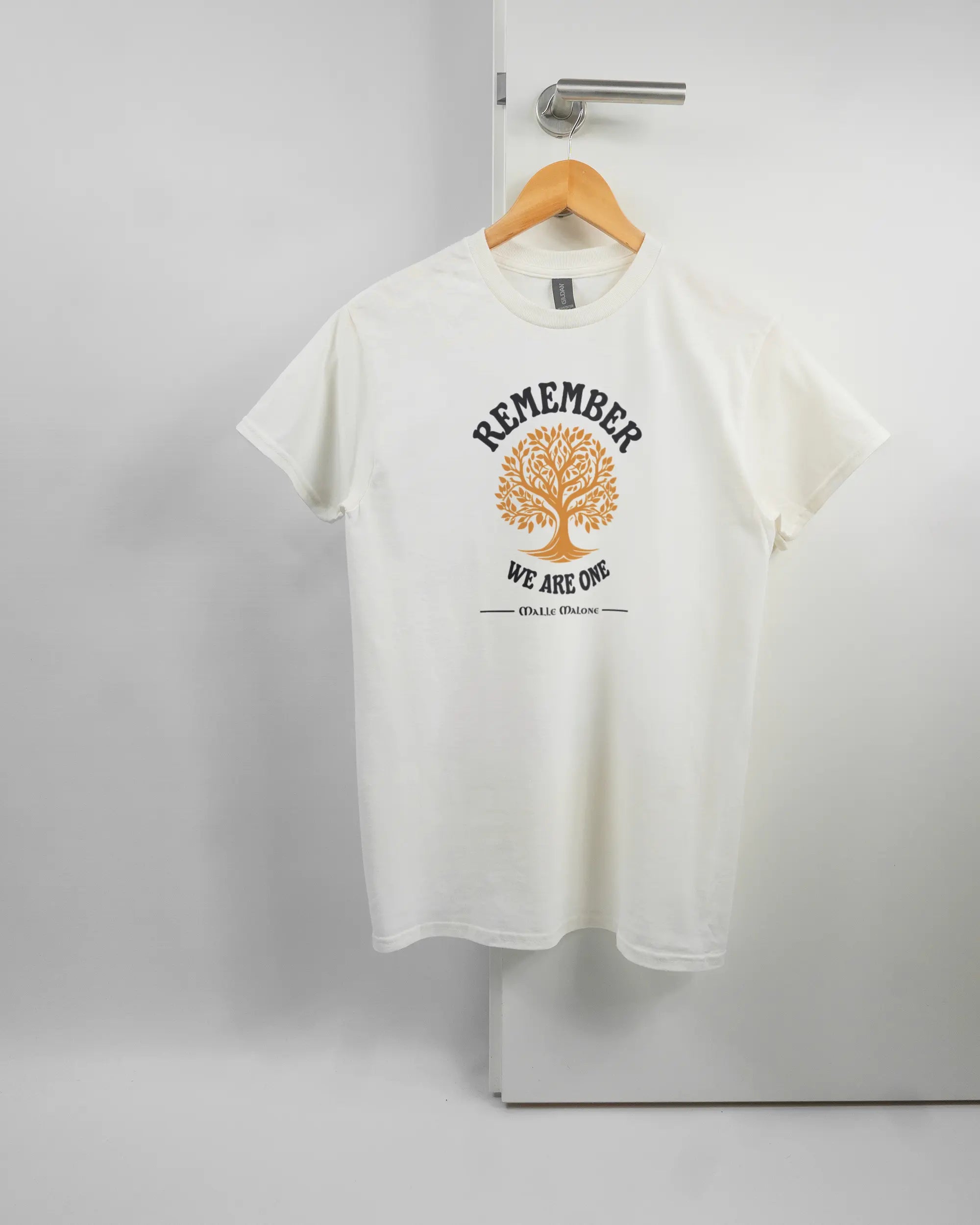 Vorderseite des Basic Unisex T-Shirt Regular von Maondo mit dem Design We are one in der Farbe White und in der Größe S auf einem Bügel an der Türklinke aufgehängt
