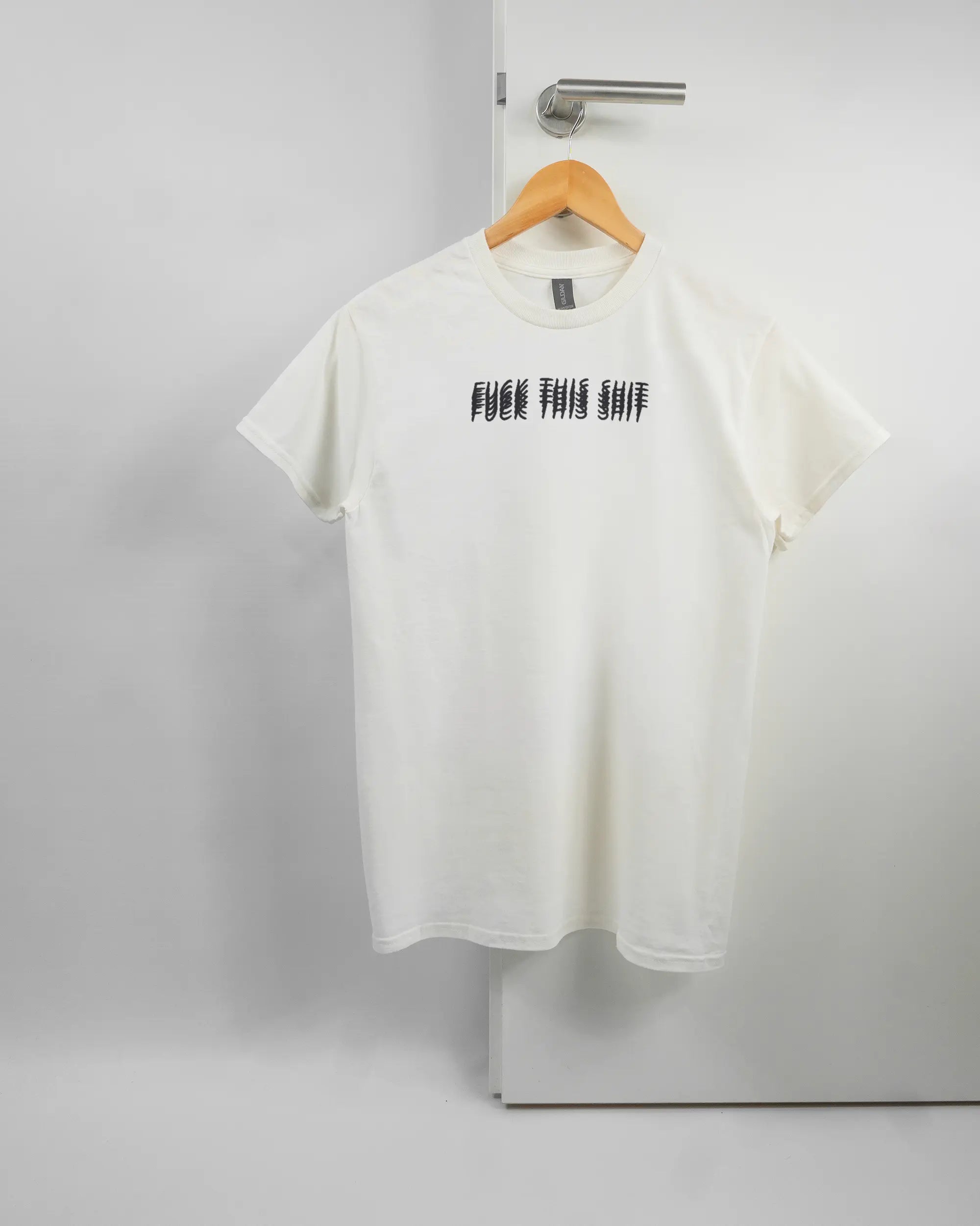 Vorderseite des Basic Unisex T-Shirt Regular von Maondo mit dem Design Hidden Message in der Farbe White und in der Größe S auf einem Bügel an der Türklinke aufgehängt