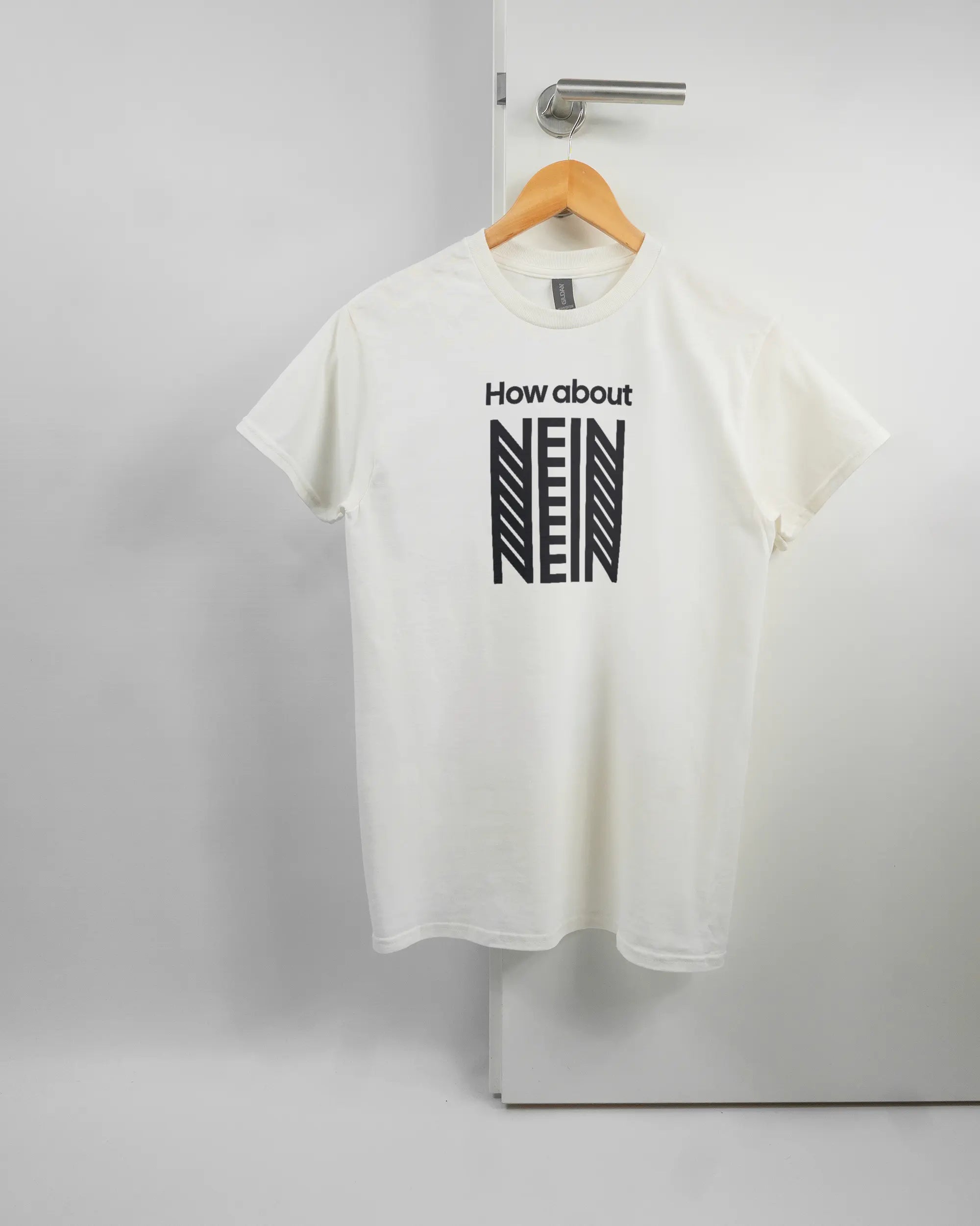Vorderseite des Basic Unisex T-Shirt Regular von Maondo mit dem Design How about nein in der Farbe White und in der Größe S auf einem Bügel an der Türklinke aufgehängt