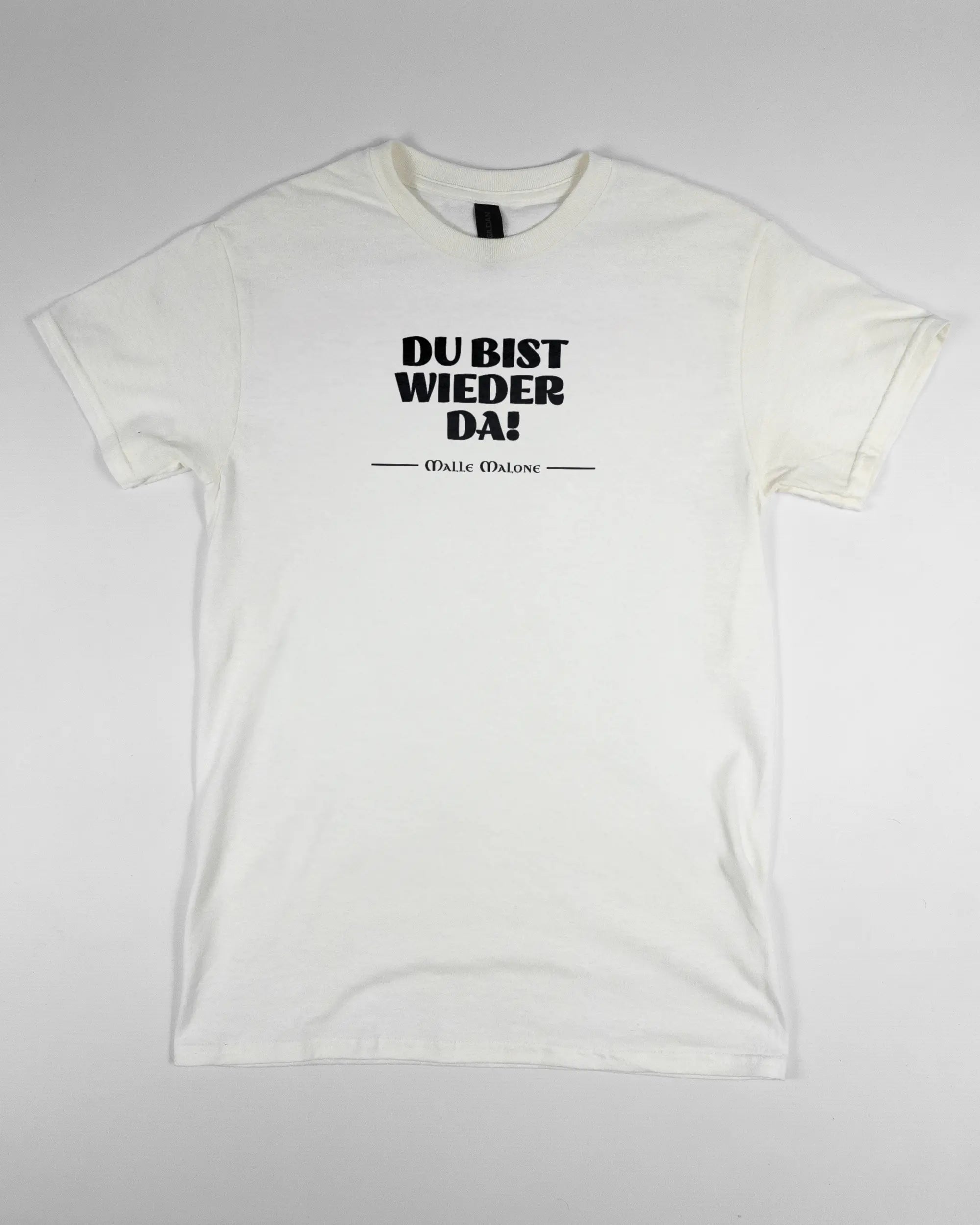 Vorderseite des Basic Unisex T-Shirt Regular von Maondo mit dem Design Wieder da in der Farbe White und in der Größe S flach auf den Boden gelegt