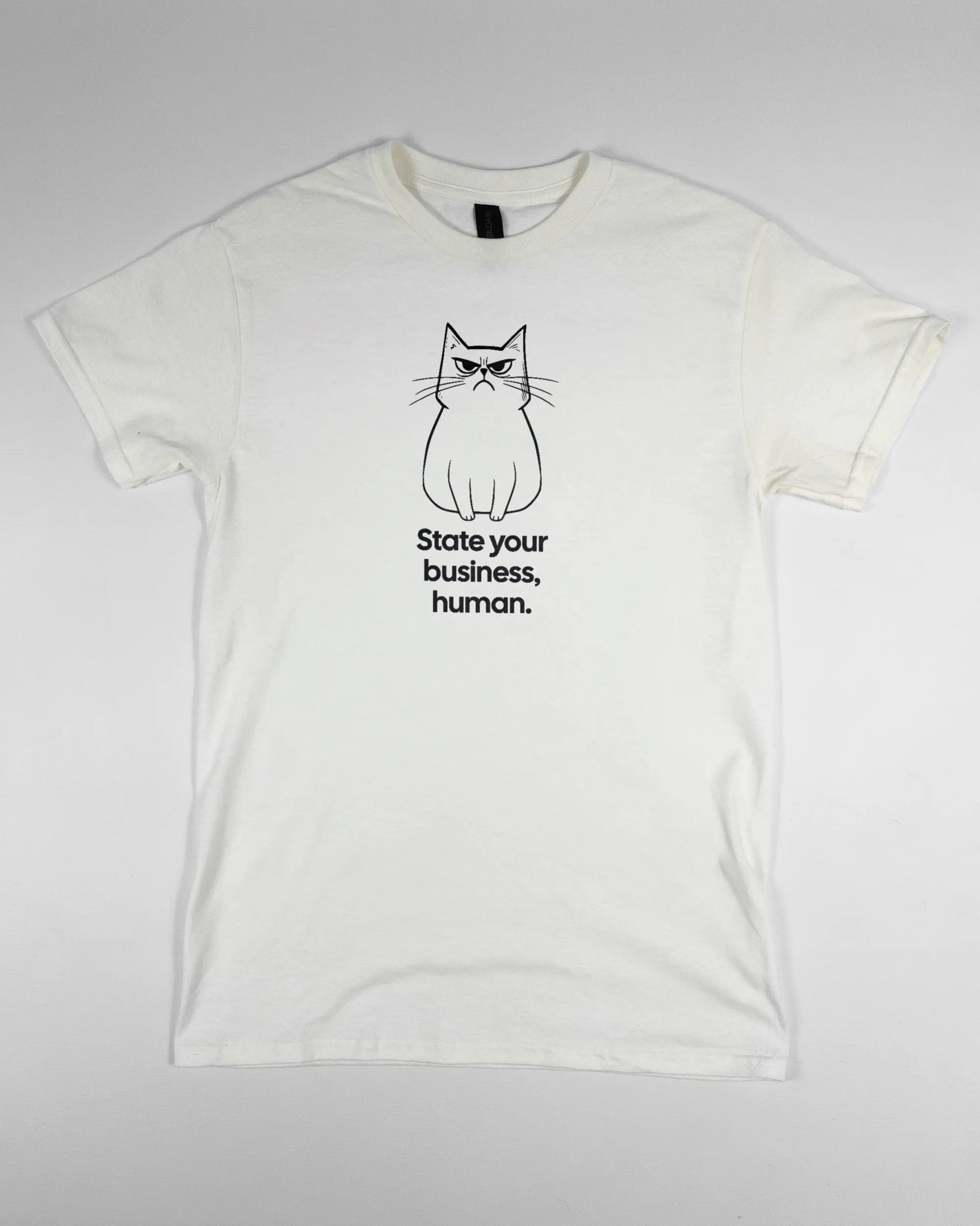 Vorderseite des Basic Unisex T-Shirt Regular von Maondo mit dem Design Grumpy Purr in der Farbe White und in der Größe S flach auf den Boden gelegt