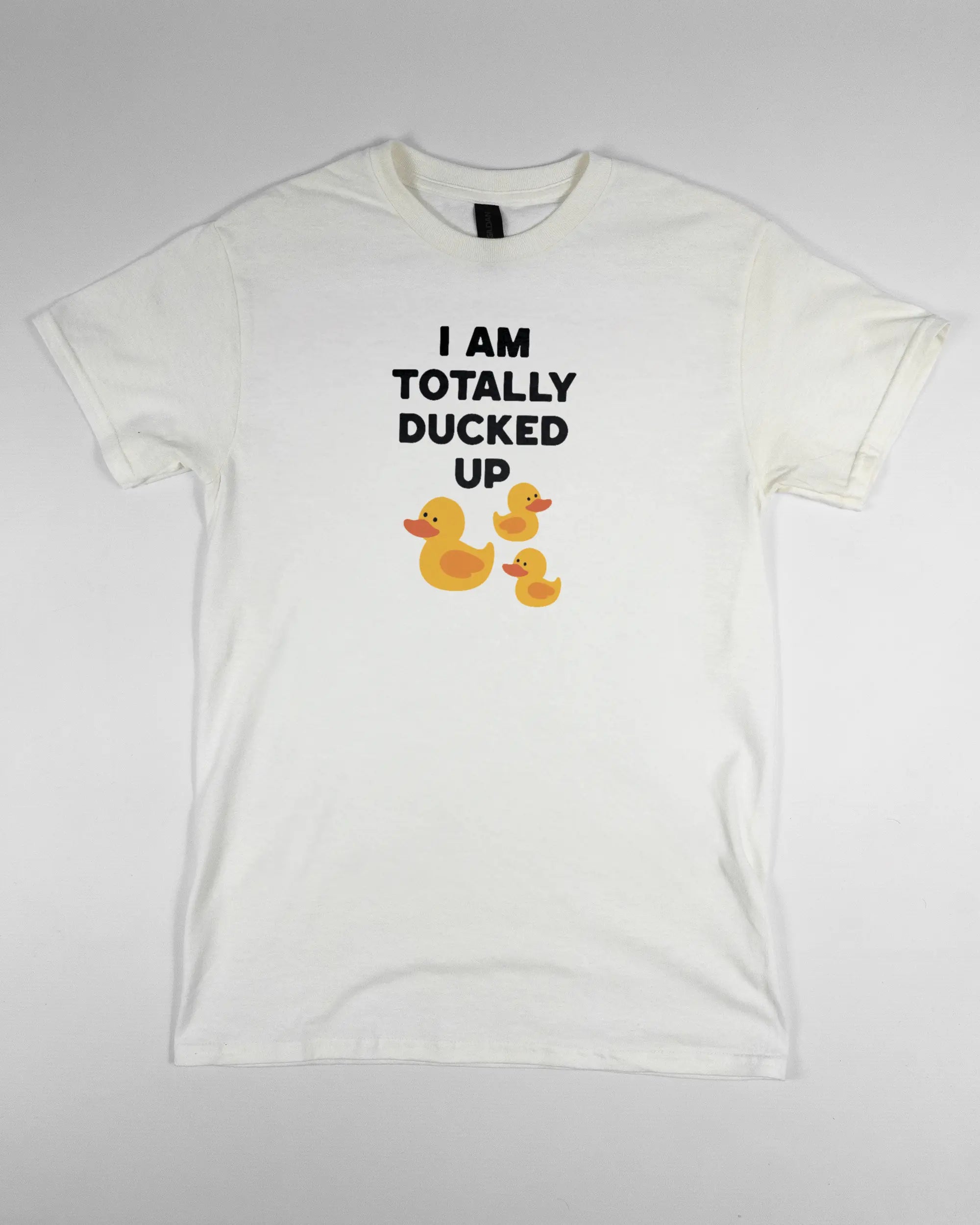 Vorderseite des Basic Unisex T-Shirt Regular von Maondo mit dem Design Ducked Up in der Farbe White und in der Größe S flach auf den Boden gelegt