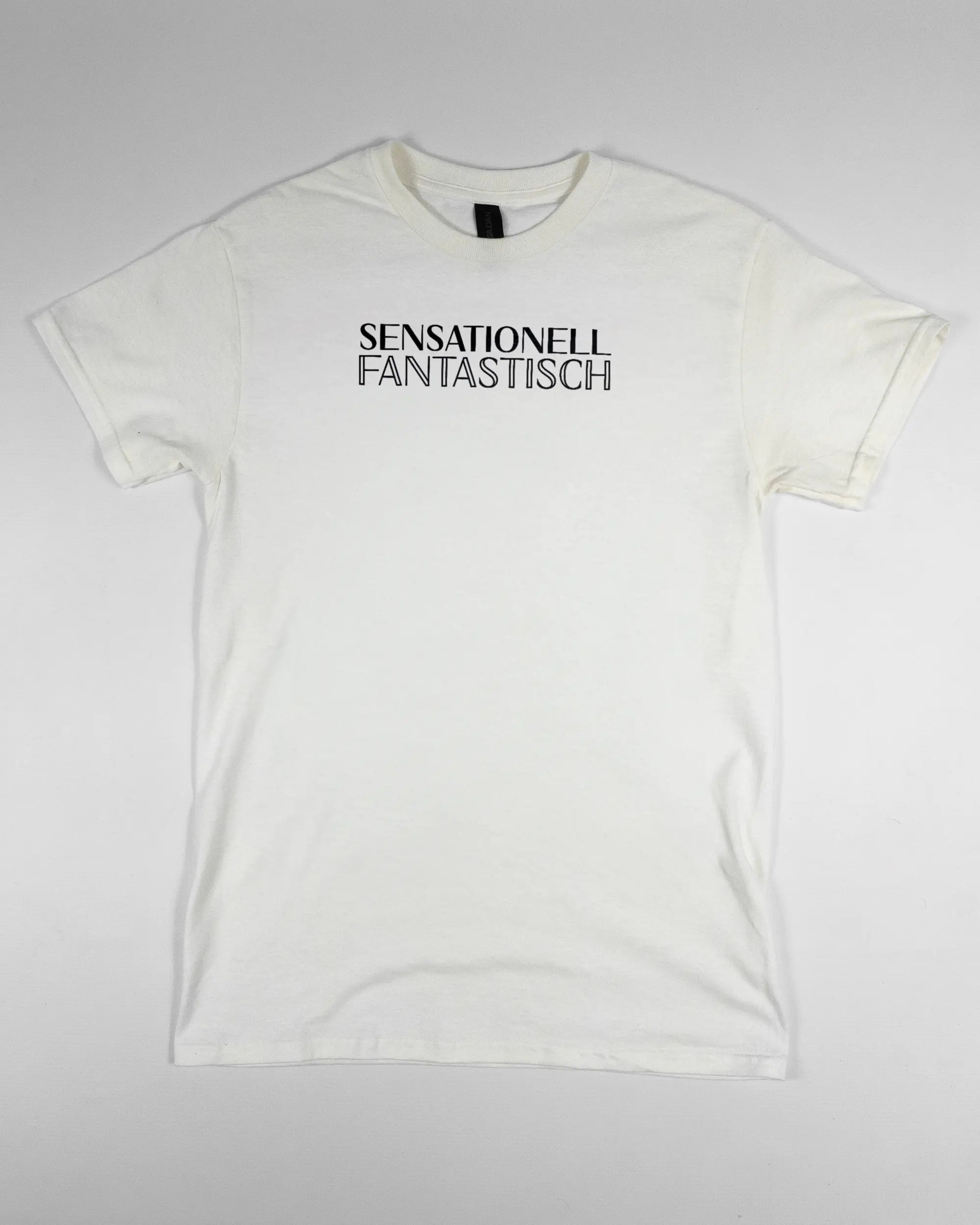 Vorderseite des Basic Unisex T-Shirt Regular von Maondo mit dem Design Sensationell in der Farbe White und in der Größe S flach auf den Boden gelegt