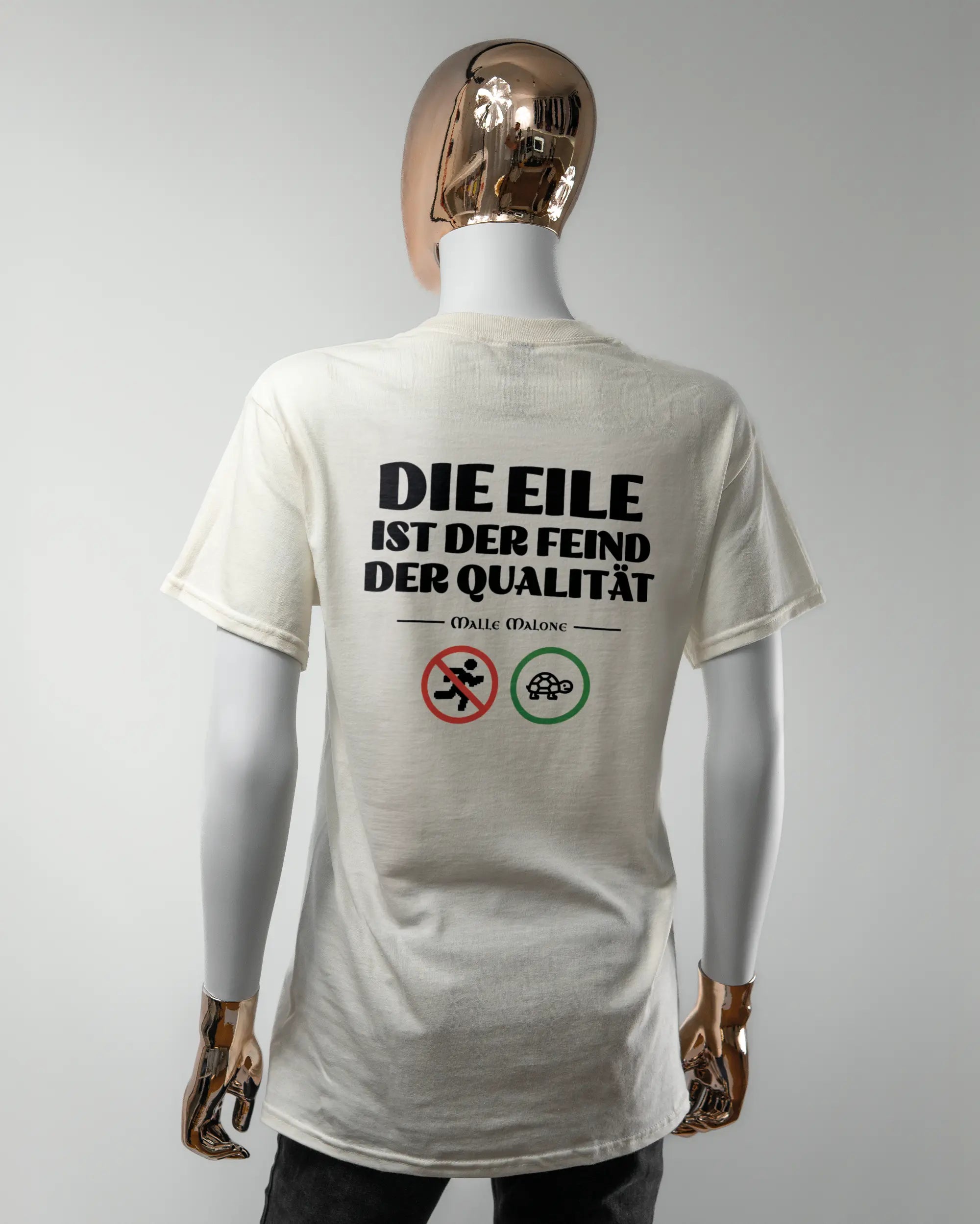 Rückseite des Basic Unisex T-Shirt Regular von Maondo mit dem Design Keine Eile in der Farbe White und in der Größe S getragen von einer femininen Puppe