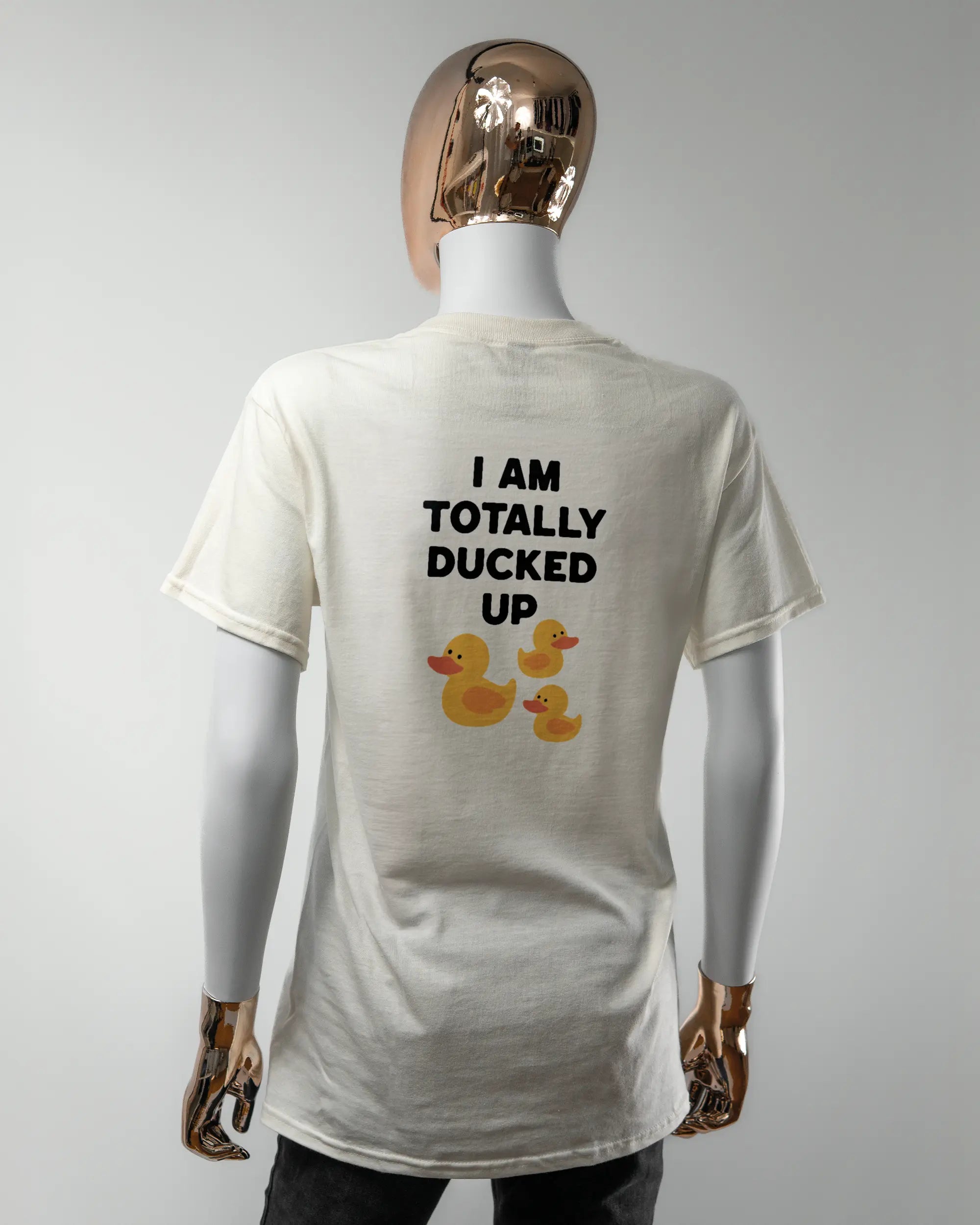 Rückseite des Basic Unisex T-Shirt Regular von Maondo mit dem Design Ducked Up in der Farbe White und in der Größe S getragen von einer femininen Puppe