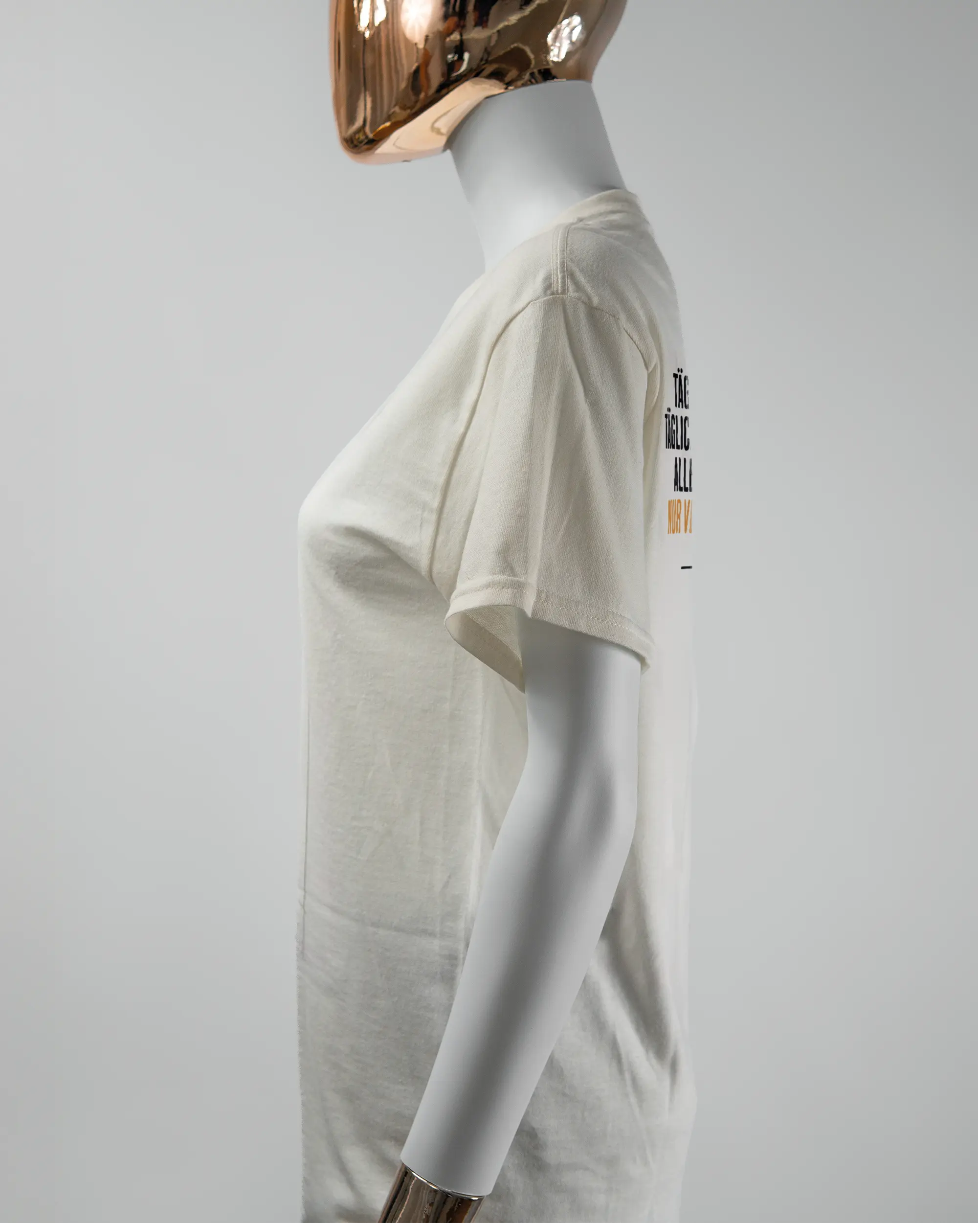 Seitenansicht des Basic Unisex T-Shirt Regular von Maondo mit dem Design Wegzeug hinten in der Farbe White und in der Größe S getragen von einer femininen Puppe