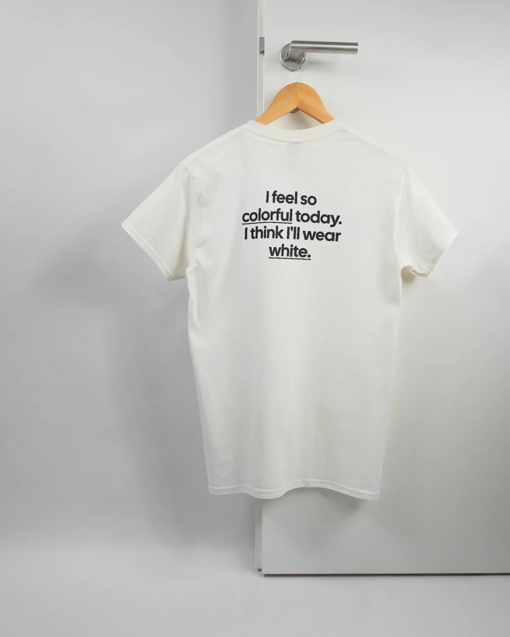 Rückseite des Basic Unisex T-Shirt Regular von Maondo mit dem Design Colorful Day in der Farbe White und in der Größe S auf einem Bügel an der Türklinke aufgehängt