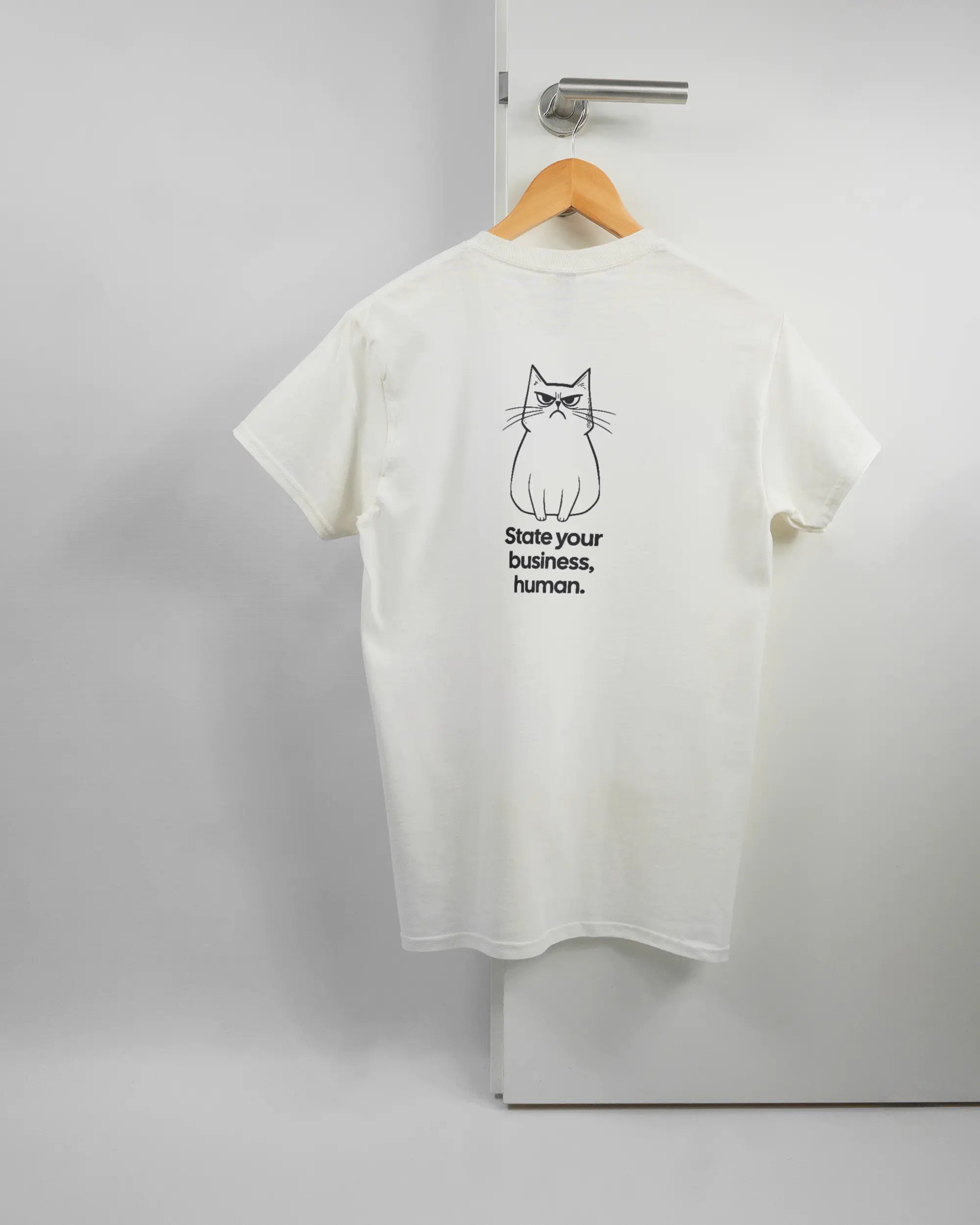 Rückseite des Basic Unisex T-Shirt Regular von Maondo mit dem Design Grumpy Purr in der Farbe White und in der Größe S auf einem Bügel an der Türklinke aufgehängt
