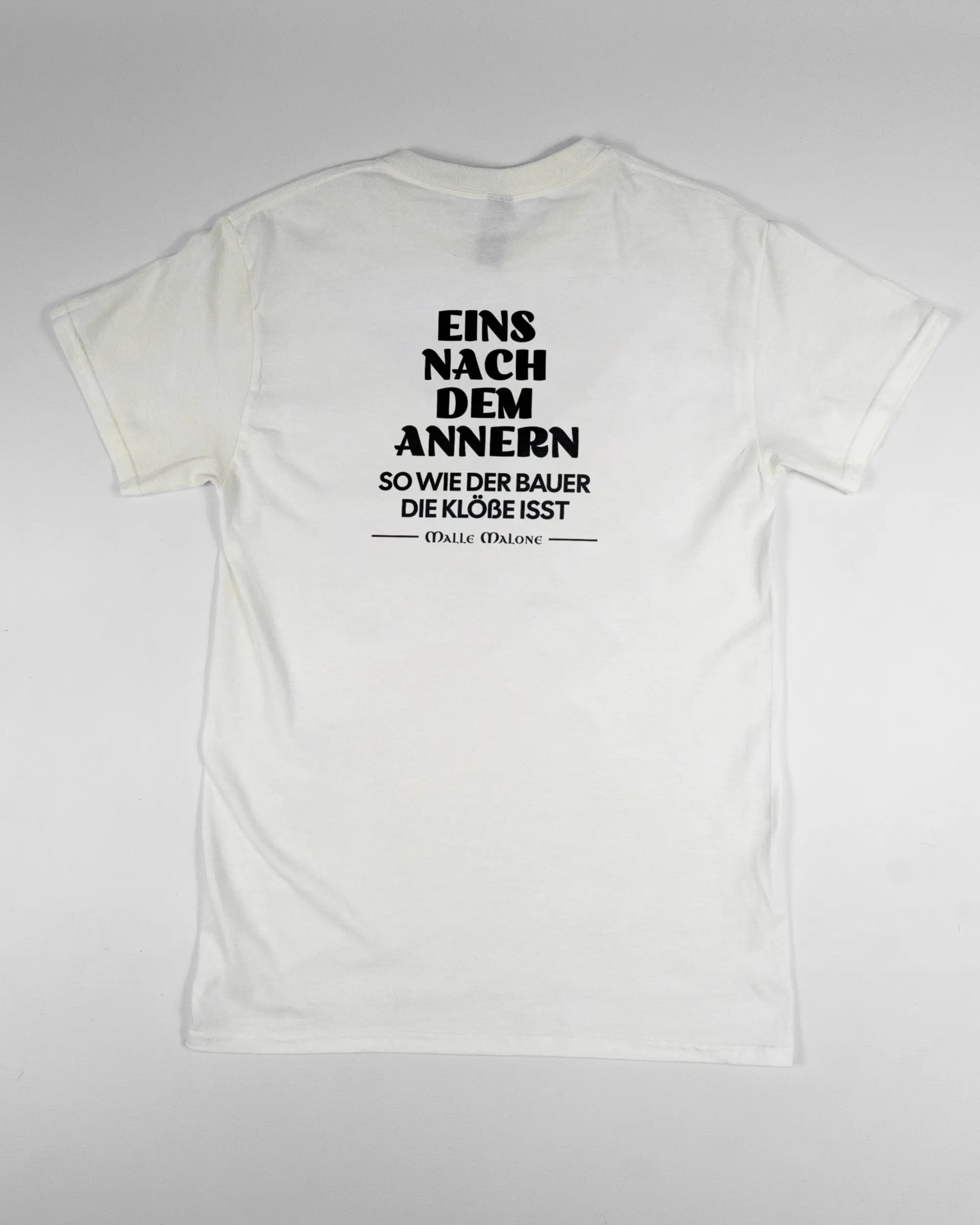 Rückseite des Basic Unisex T-Shirt Regular von Maondo mit dem Design Eins nach dem Annern in der Farbe White und in der Größe S flach auf den Boden gelegt