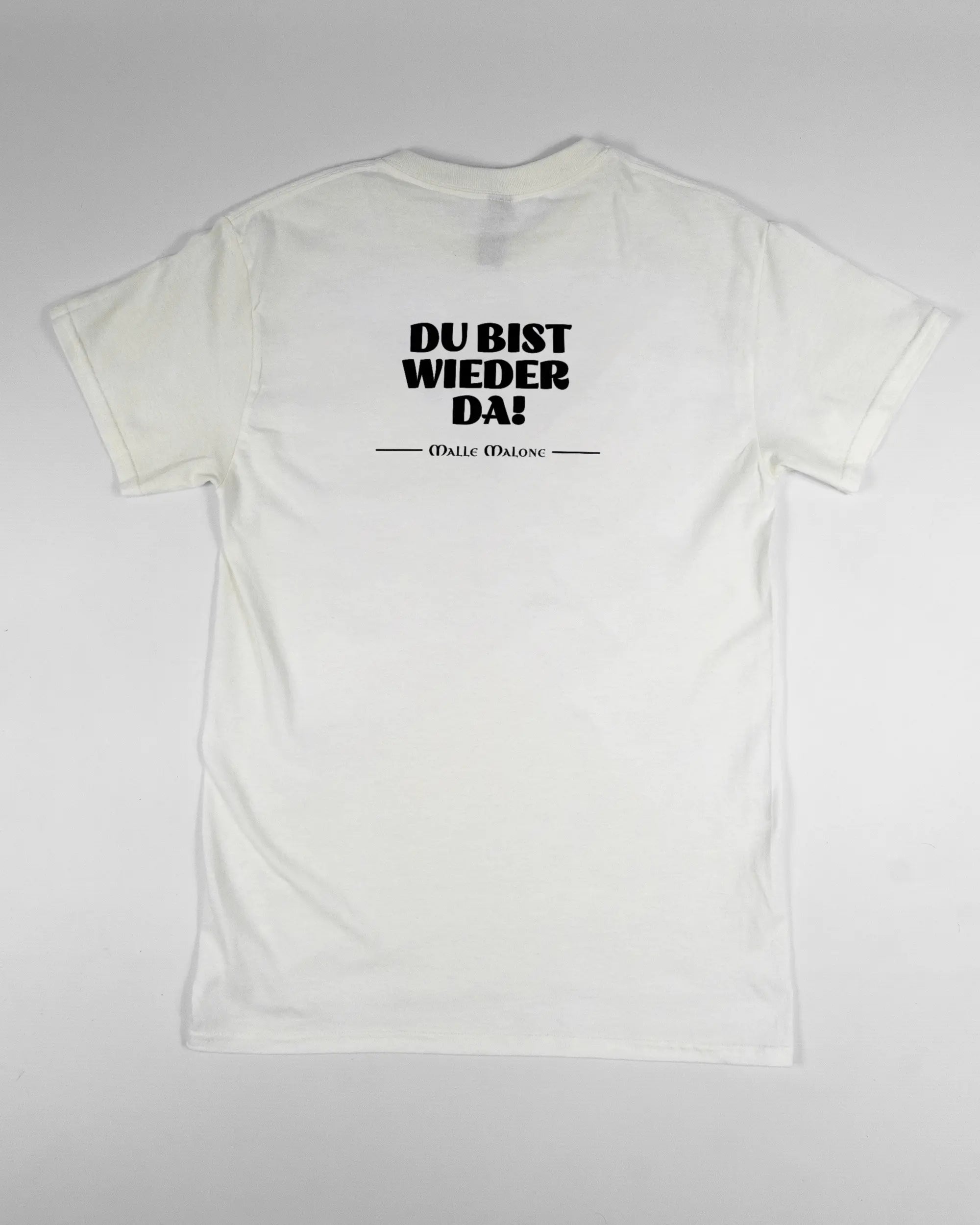Rückseite des Basic Unisex T-Shirt Regular von Maondo mit dem Design Wieder da in der Farbe White und in der Größe S flach auf den Boden gelegt