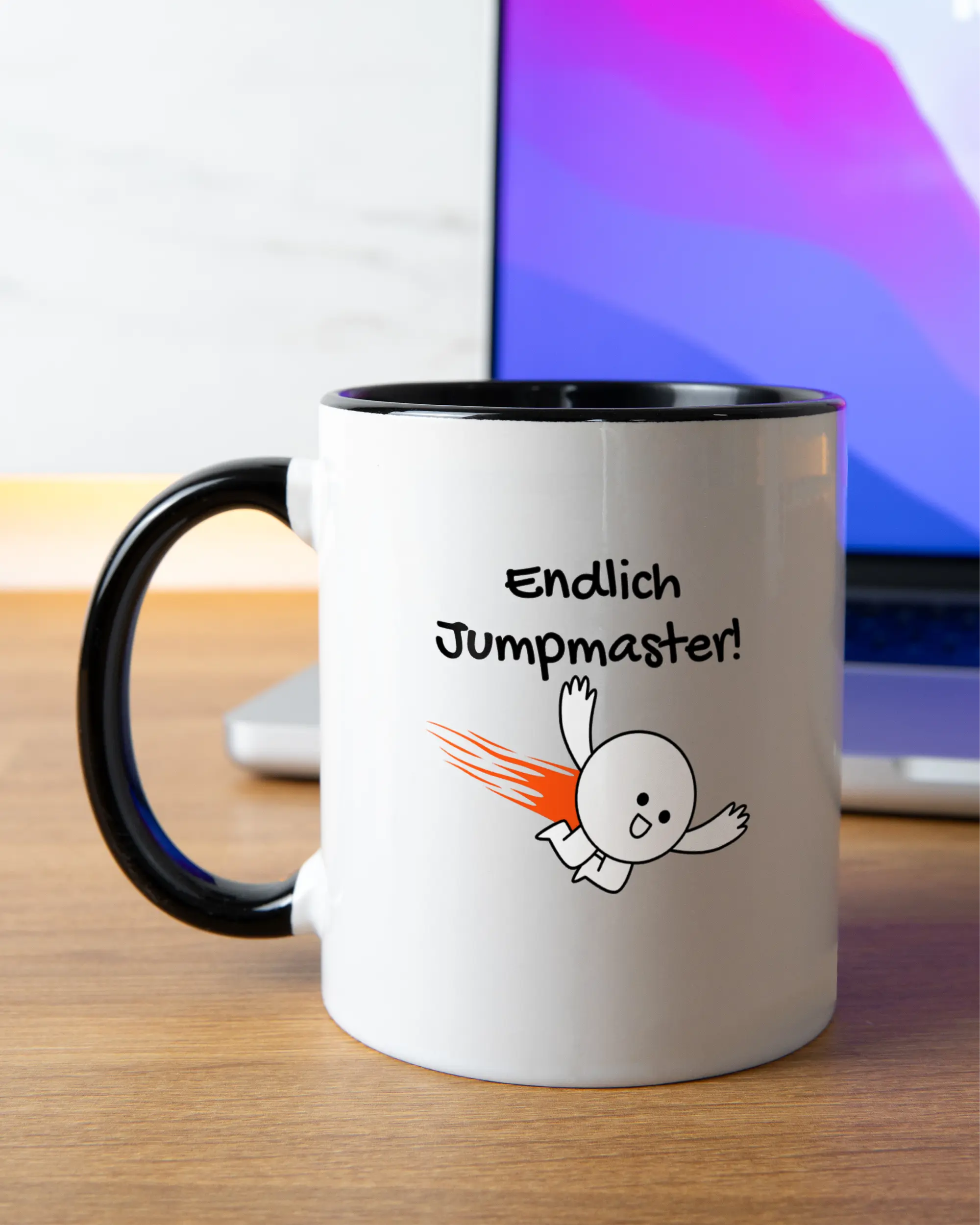 Homeoffice Aufnahme der beidseitig bedruckten Keramik Tasse von Maondo mit dem Design Endlich Jumpmaster in der Farbe Schwarz-Weiß