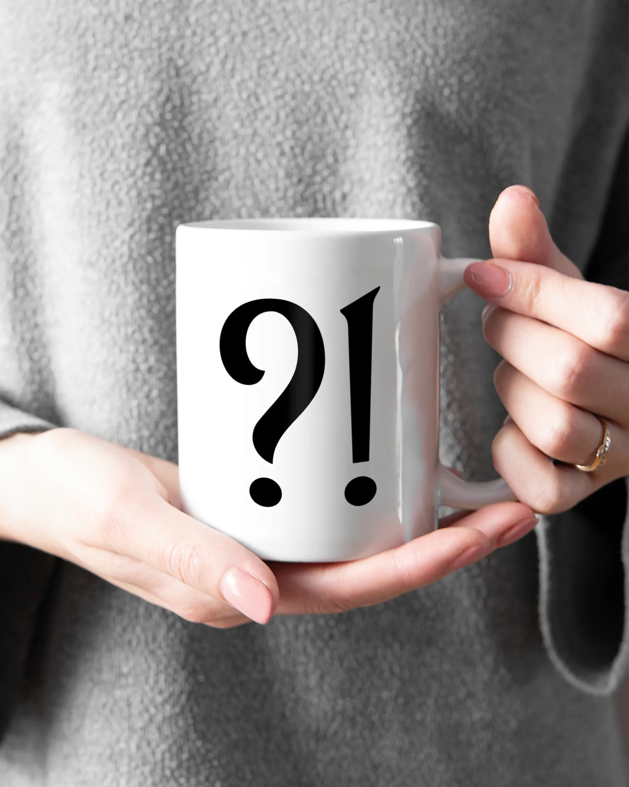 Rechte Seite der beidseitig bedruckten Keramiktasse von Maondo mit dem Design WHAT in der Farbe White gehalten von Frauenhänden