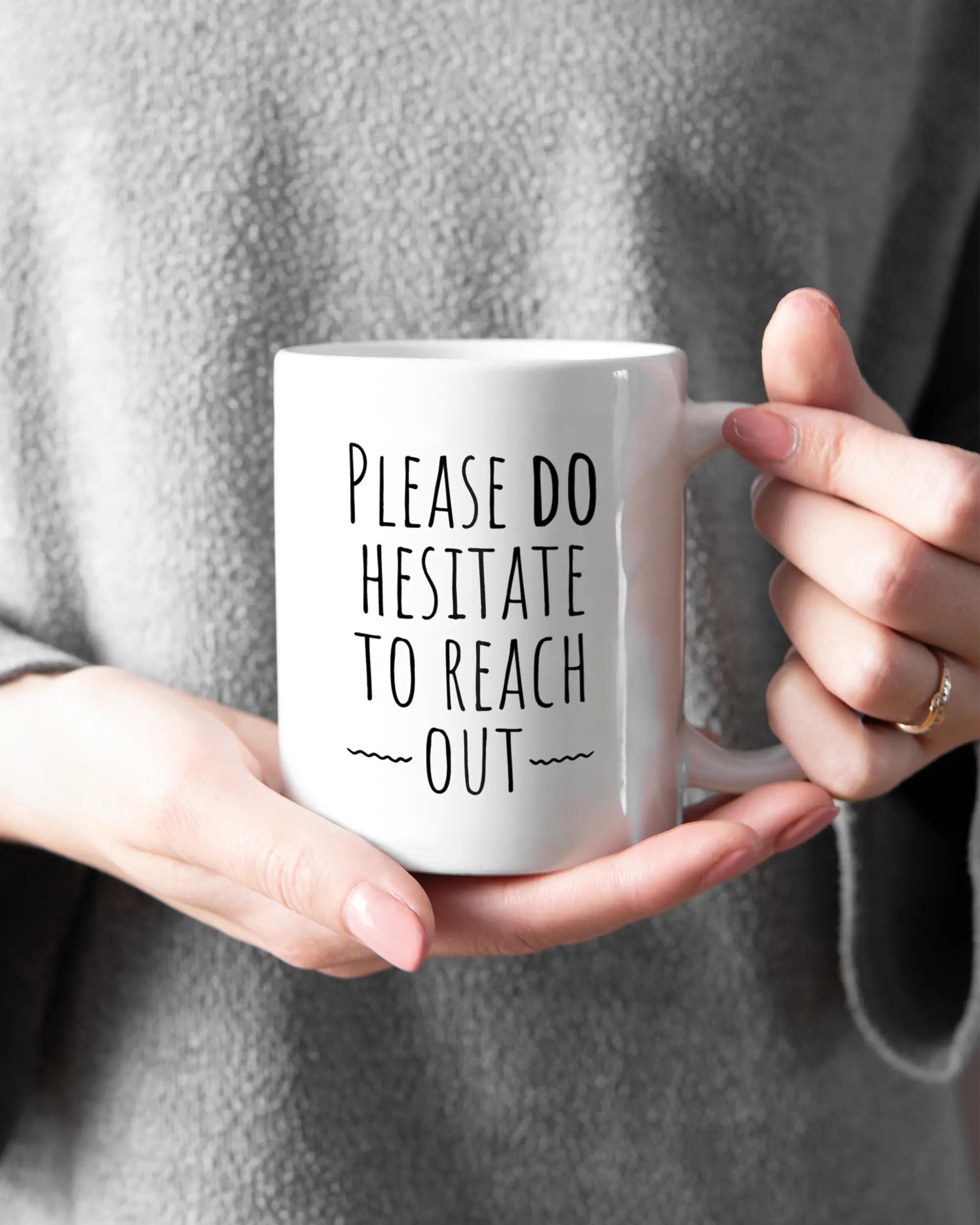 Rechte Seite der beidseitig bedruckten Keramiktasse von Maondo mit dem Design Please Hesitate in der Farbe White gehalten von Frauenhänden