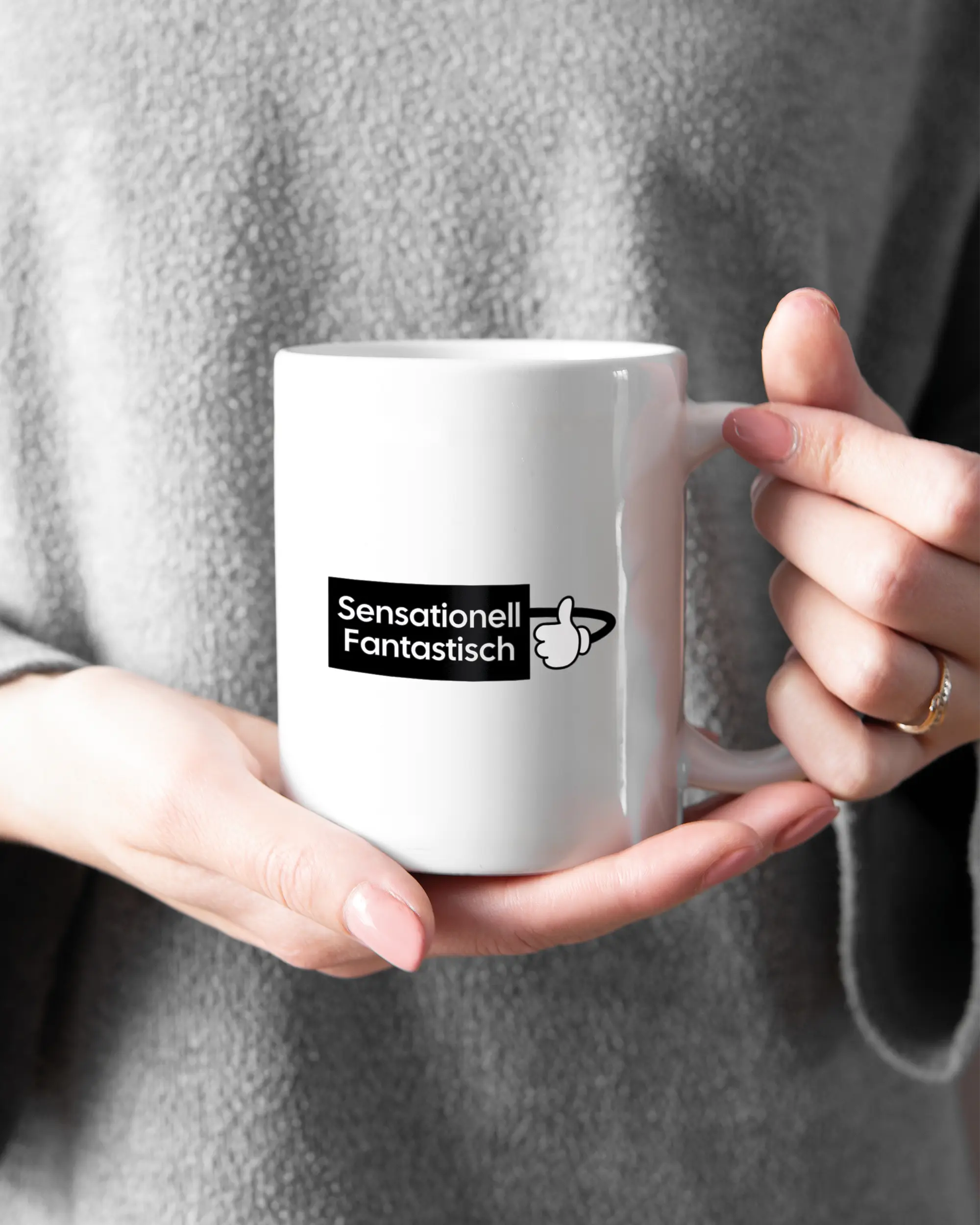 Rechte Seite der beidseitig bedruckten Keramiktasse von Maondo mit dem Design Fantastisch in der Farbe White gehalten von Frauenhänden