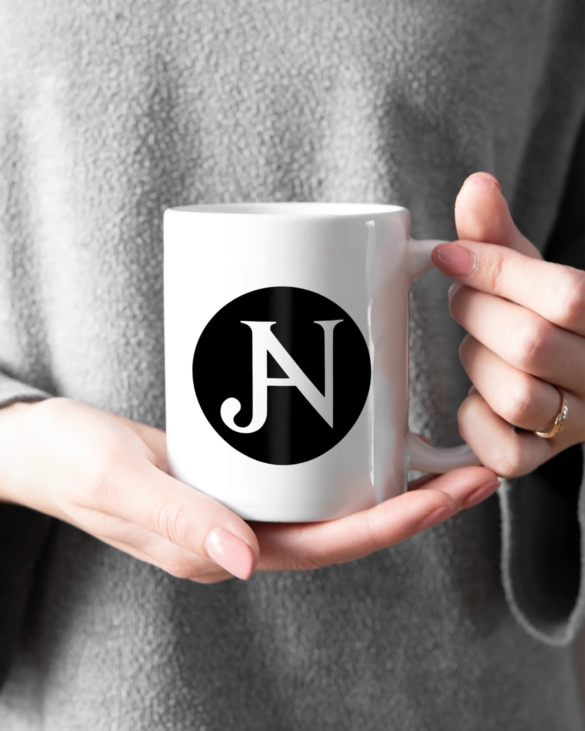 Rechte Seite der beidseitig bedruckten Keramiktasse von Maondo mit dem Design JB1 in der Farbe White gehalten von Frauenhänden