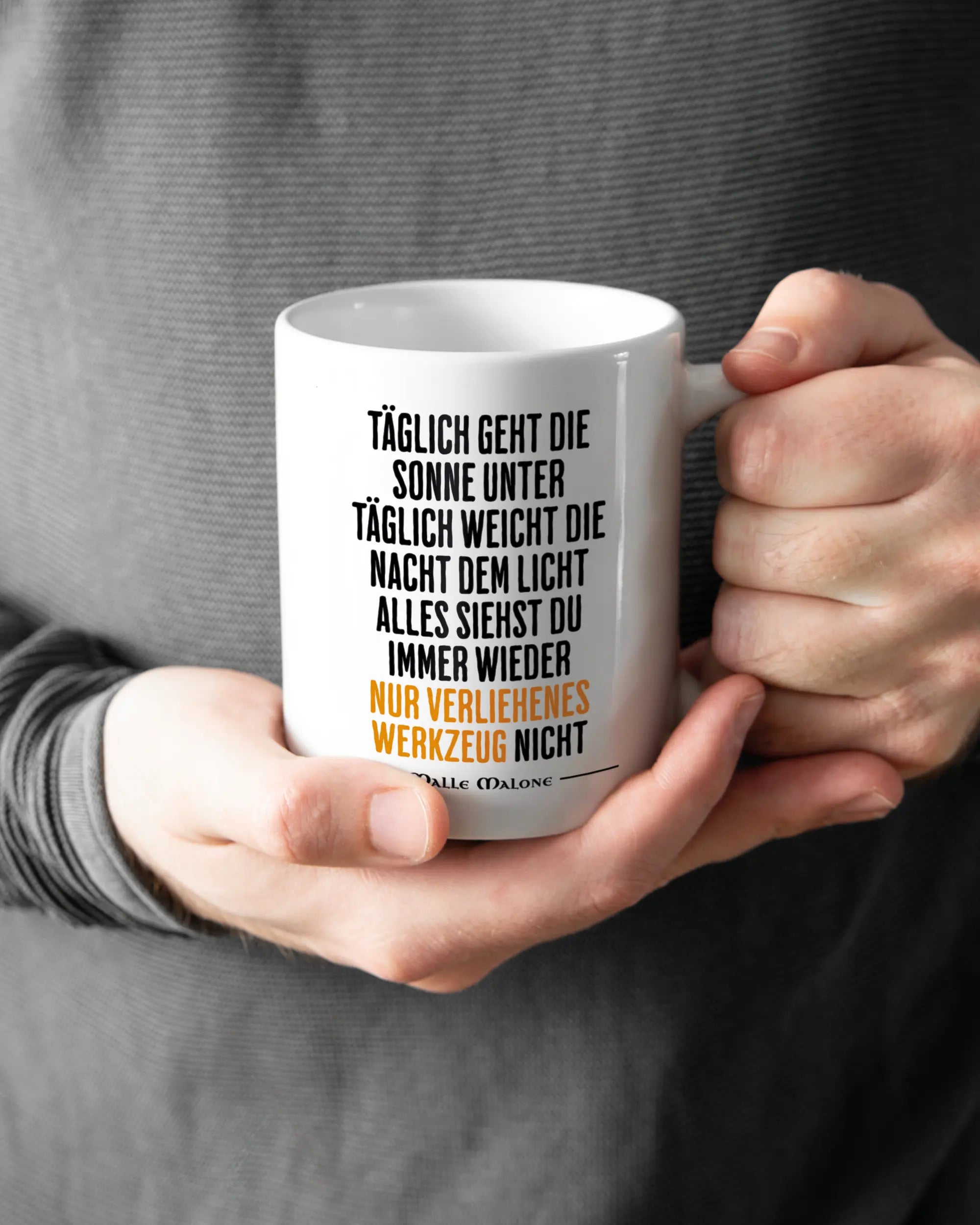 Rechte Seite der beidseitig bedruckten Keramiktasse von Maondo mit dem Design Wegzeug in der Farbe White gehalten von Männerhänden