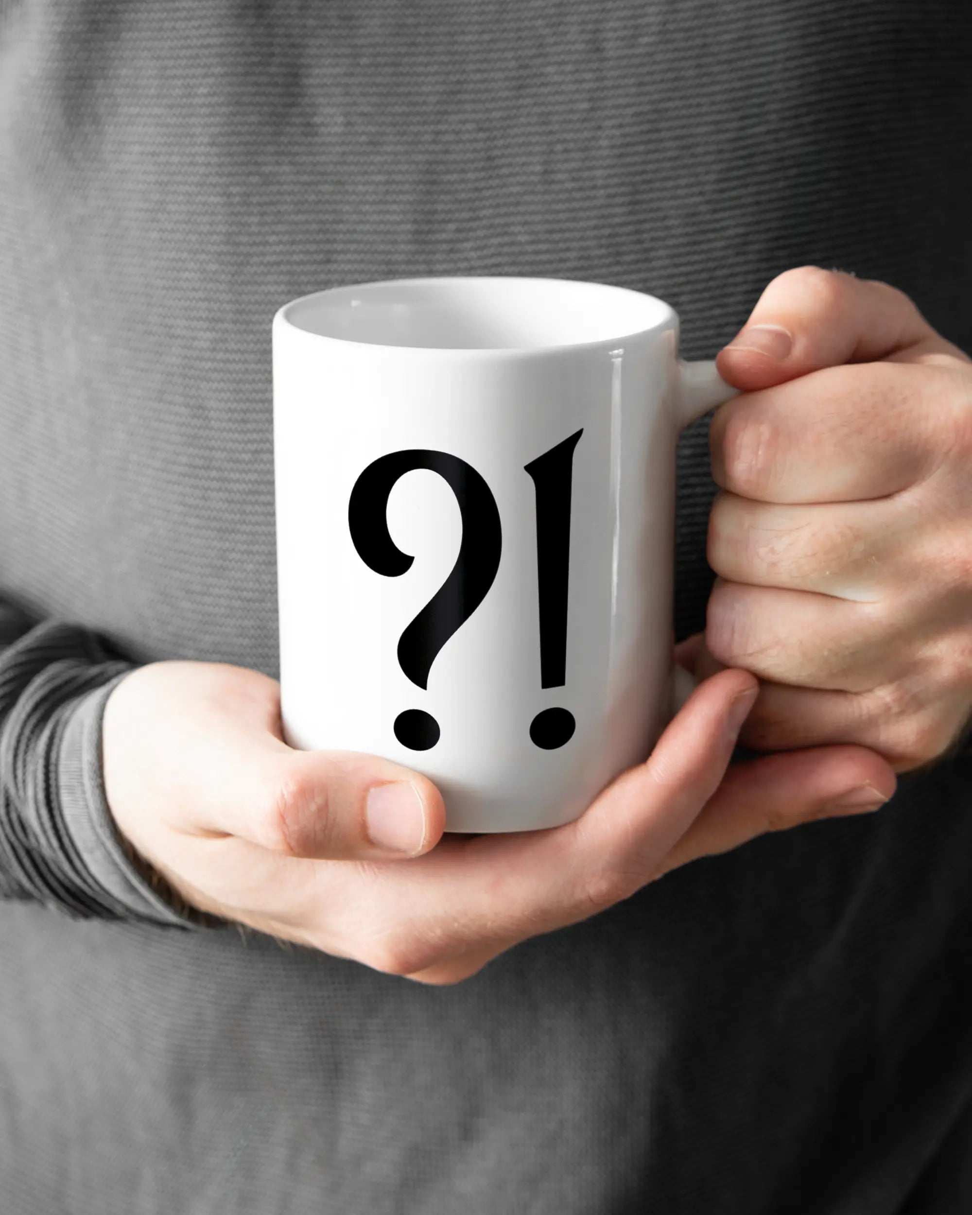 Rechte Seite der beidseitig bedruckten Keramiktasse von Maondo mit dem Design WHAT in der Farbe White gehalten von Männerhänden