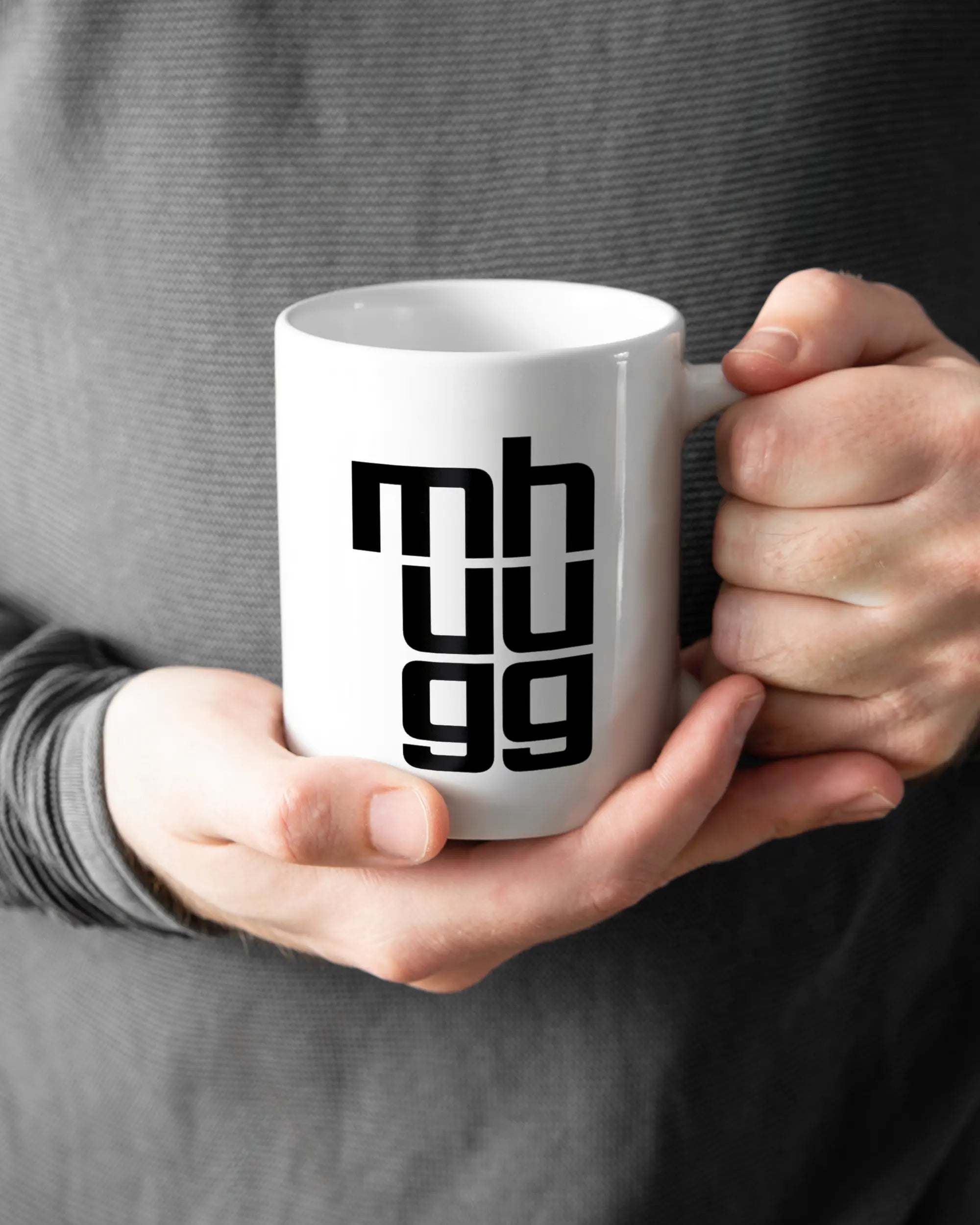 Rechte Seite der beidseitig bedruckten Keramiktasse von Maondo mit dem Design Hug Mug in der Farbe White gehalten von Männerhänden