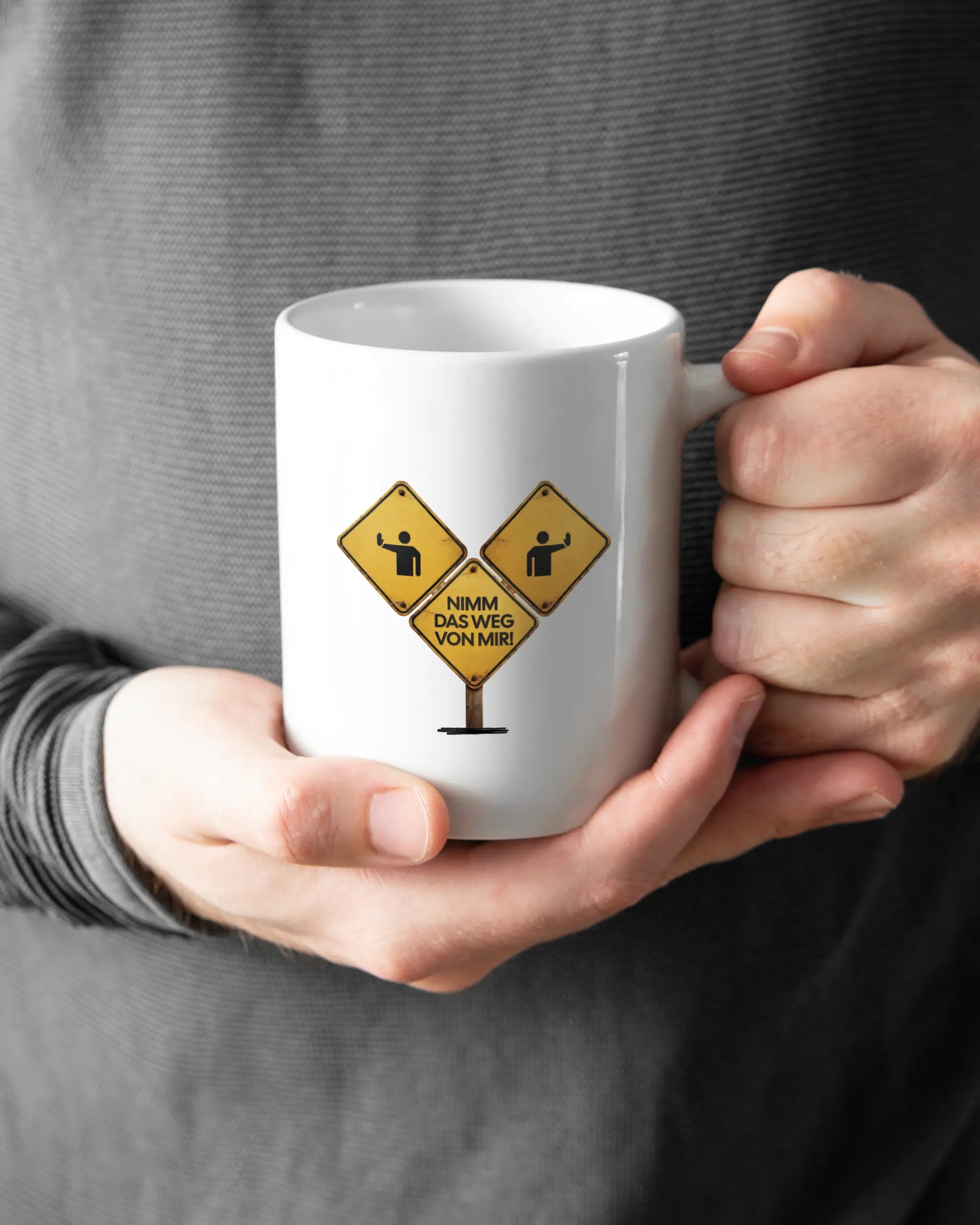 Rechte Seite der beidseitig bedruckten Keramiktasse von Maondo mit dem Design Schutzschild in der Farbe White gehalten von Männerhänden