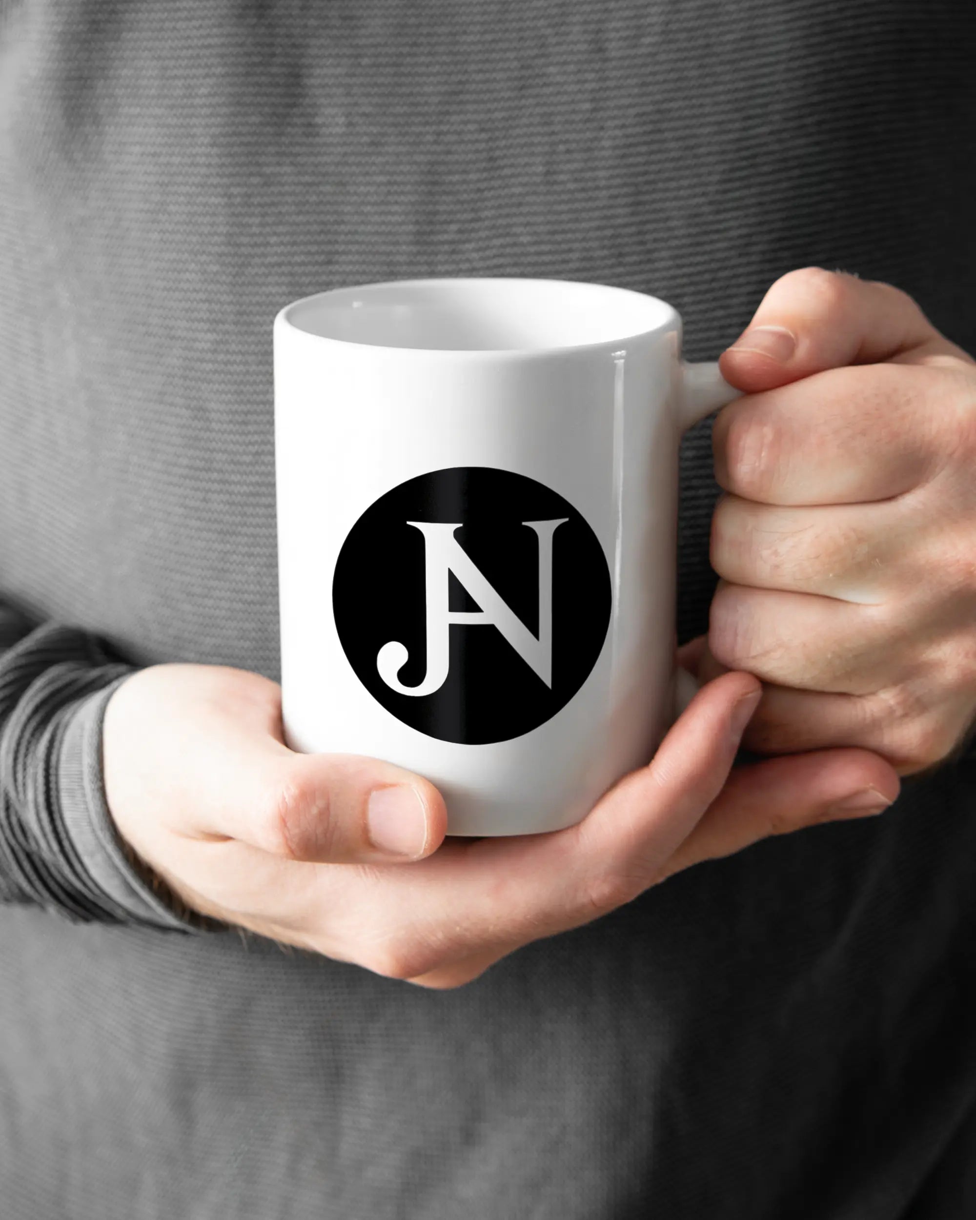 Rechte Seite der beidseitig bedruckten Keramiktasse von Maondo mit dem Design JB1 in der Farbe White gehalten von Männerhänden