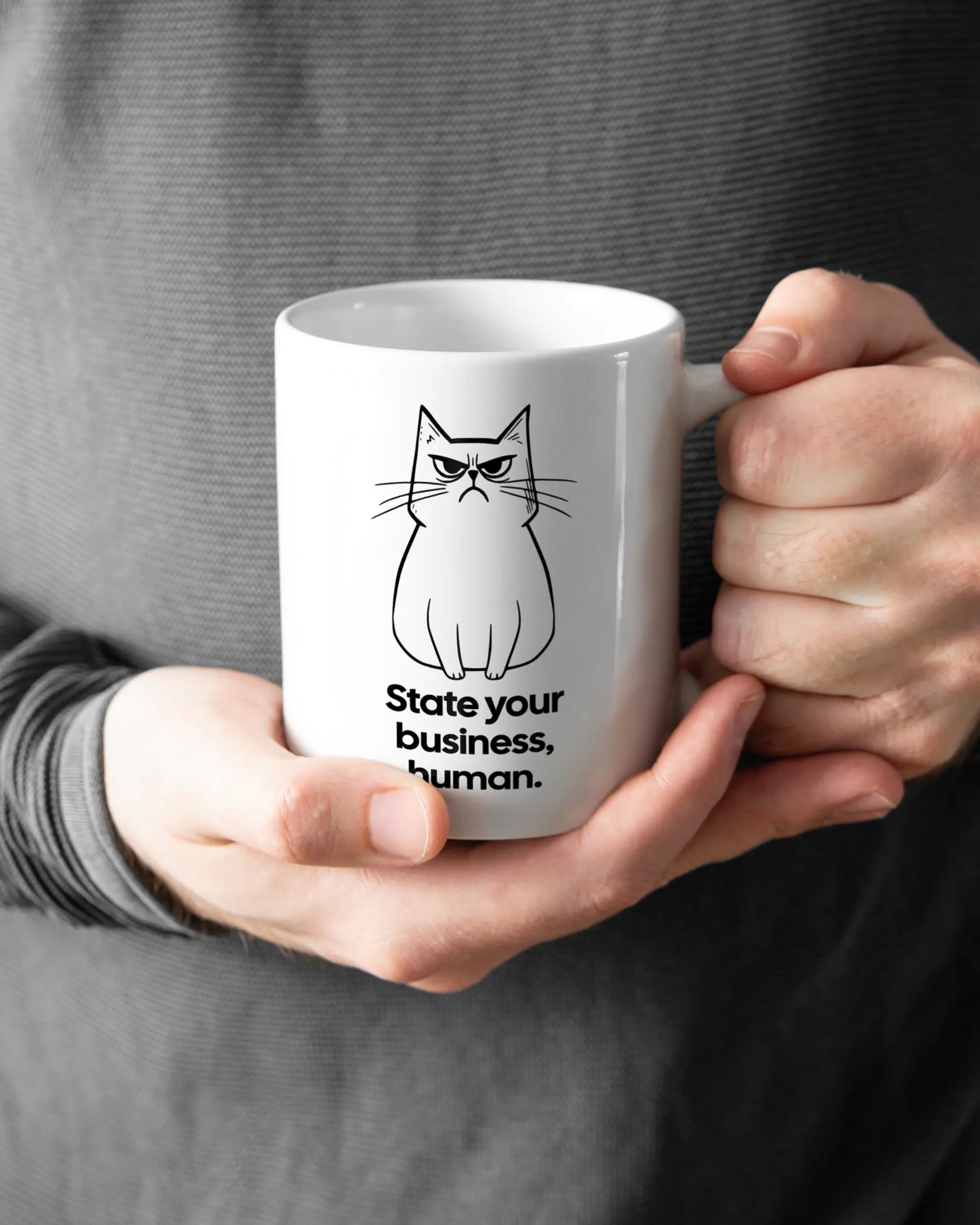 Rechte Seite der beidseitig bedruckten Keramiktasse von Maondo mit dem Design Grumpy Purr in der Farbe White gehalten von Männerhänden