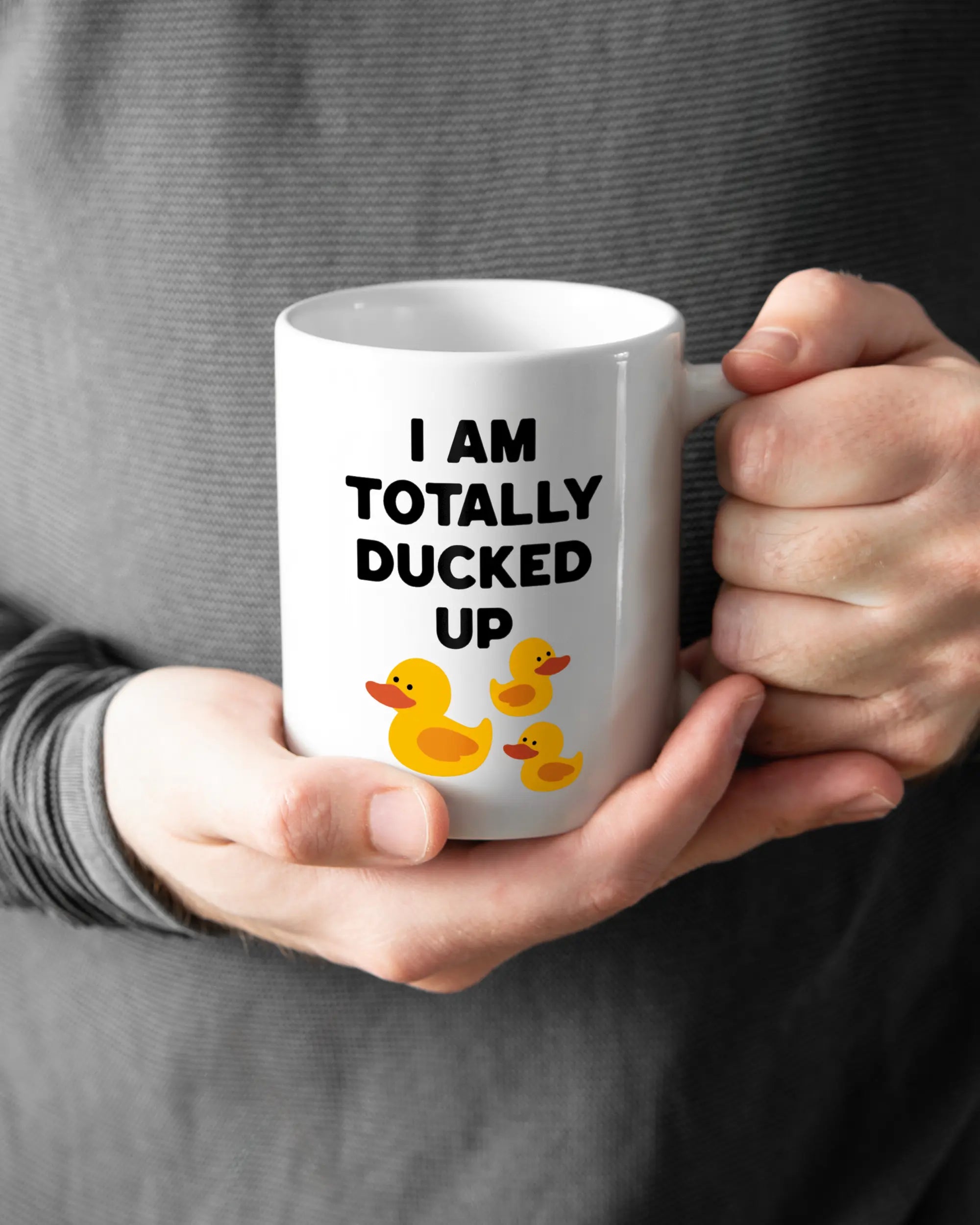 Rechte Seite der beidseitig bedruckten Keramiktasse von Maondo mit dem Design Ducked Up in der Farbe White gehalten von Männerhänden