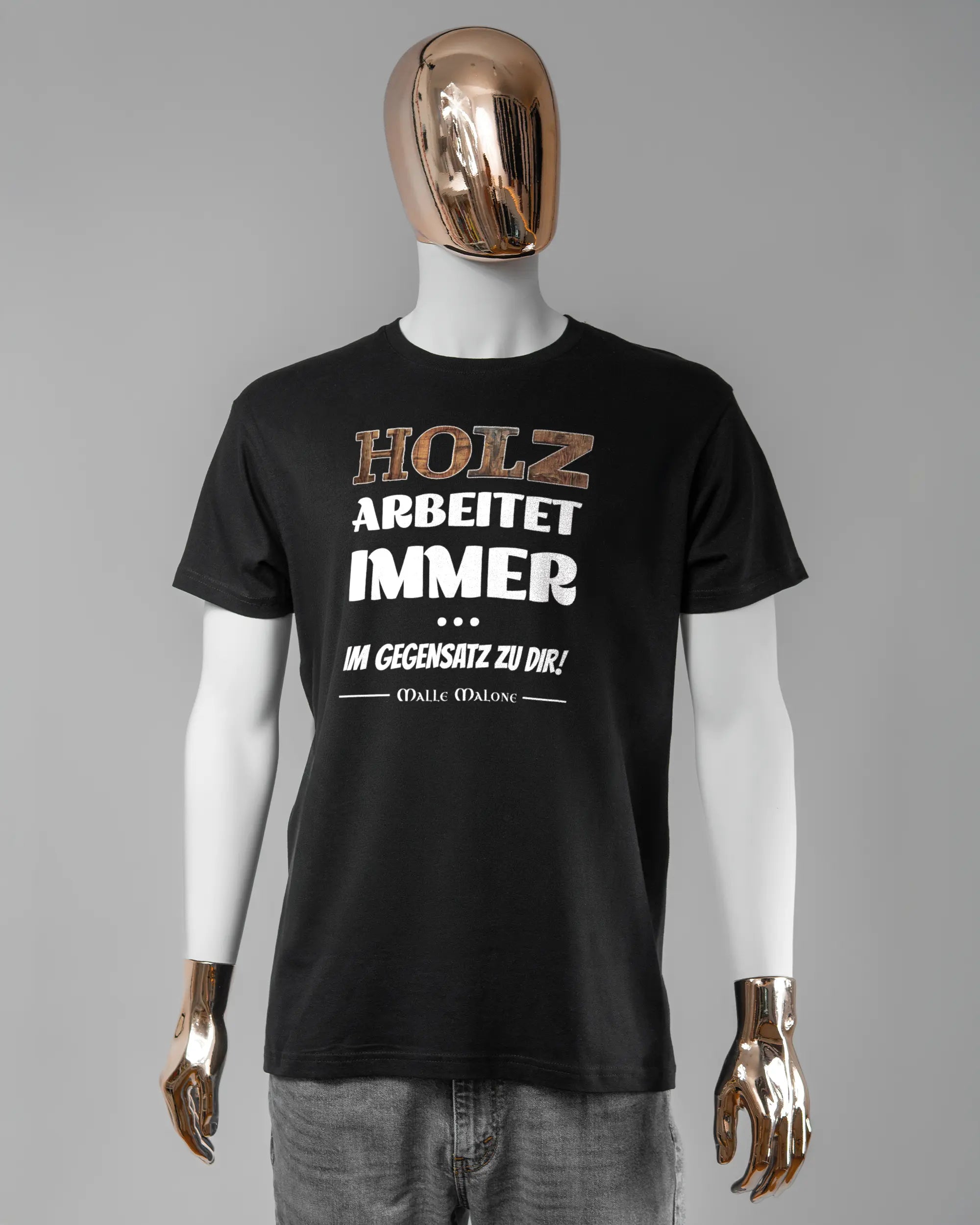 Vorderseite des Basic Unisex T-Shirt Soft von Maondo mit dem Design Holzarbeit in der Farbe Black und in der Größe L getragen von einer maskulinen Puppe