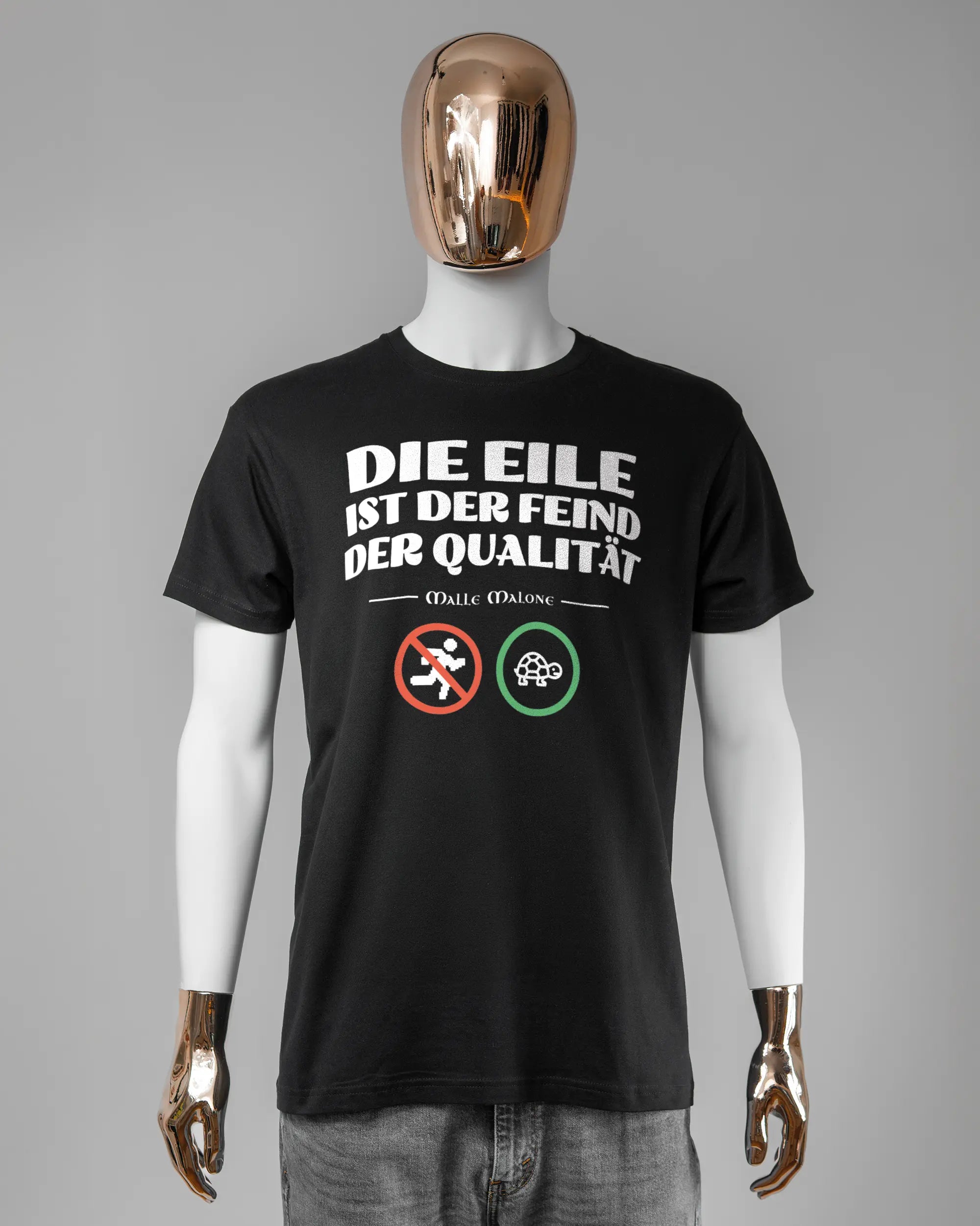 Vorderseite des Basic Unisex T-Shirt Soft von Maondo mit dem Design Keine Eile in der Farbe Black und in der Größe L getragen von einer maskulinen Puppe
