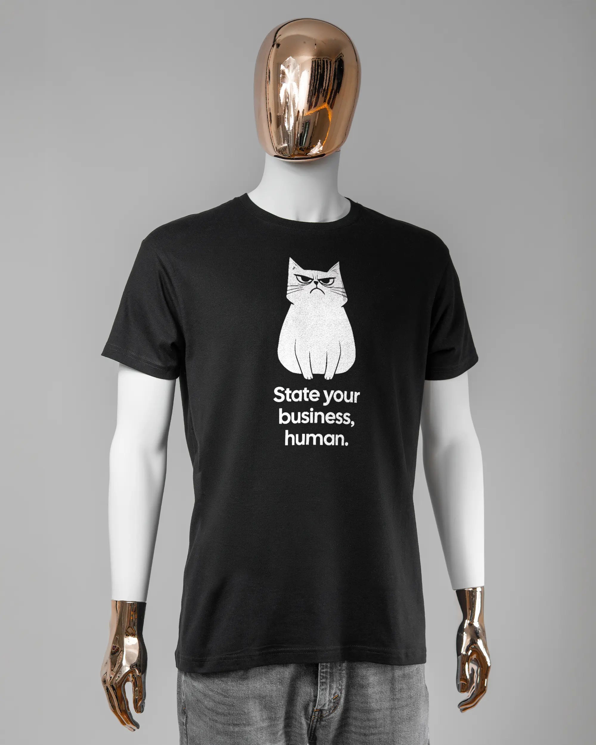 Vorderseite des Basic Unisex T-Shirt Soft von Maondo mit dem Design Grumpy Purr in der Farbe Black und in der Größe L getragen von einer maskulinen Puppe