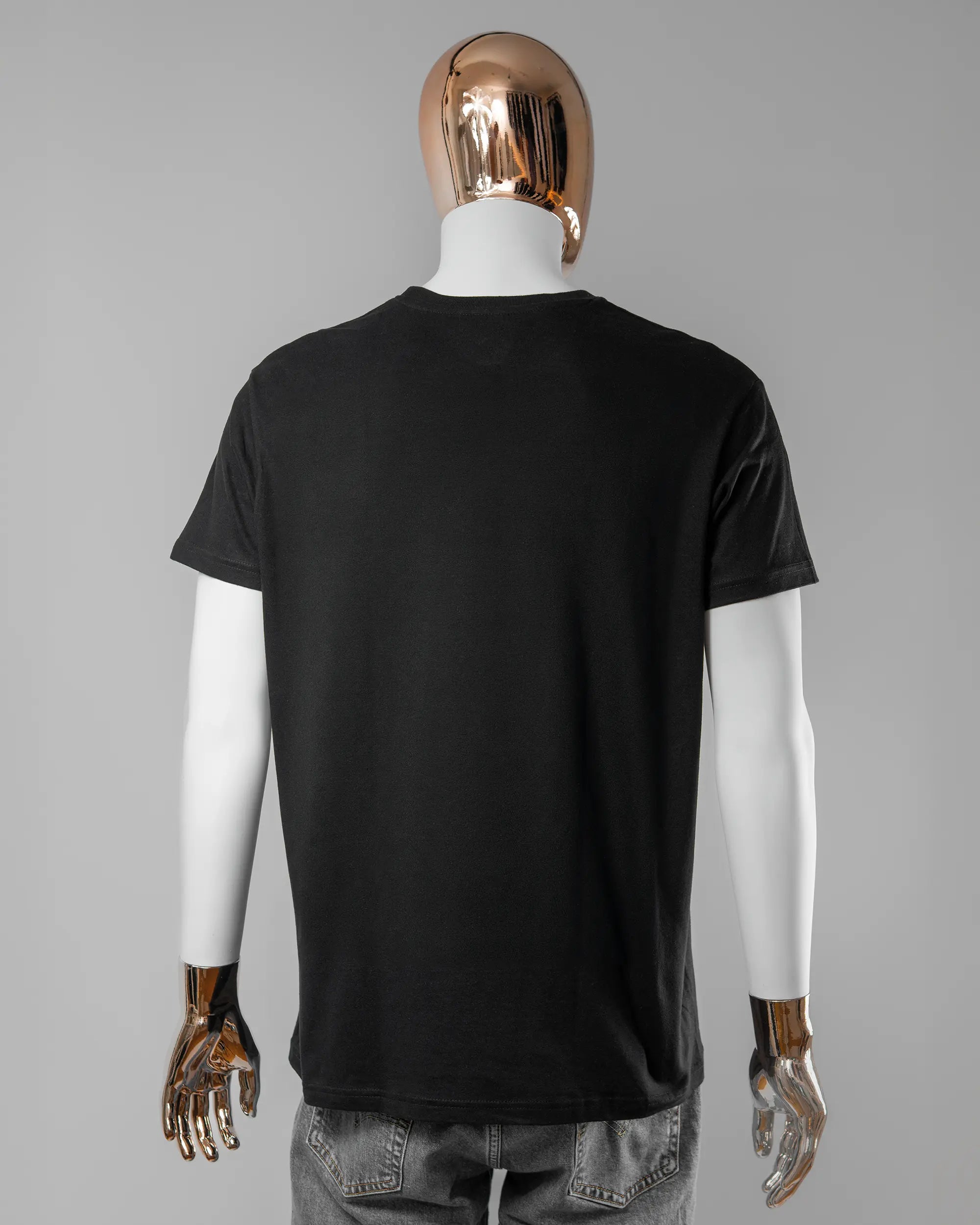 Rückseite des Basic Unisex T-Shirt Soft von Maondo ohne Motiv in der Farbe Black und in der Größe L getragen von einer maskulinen Puppe