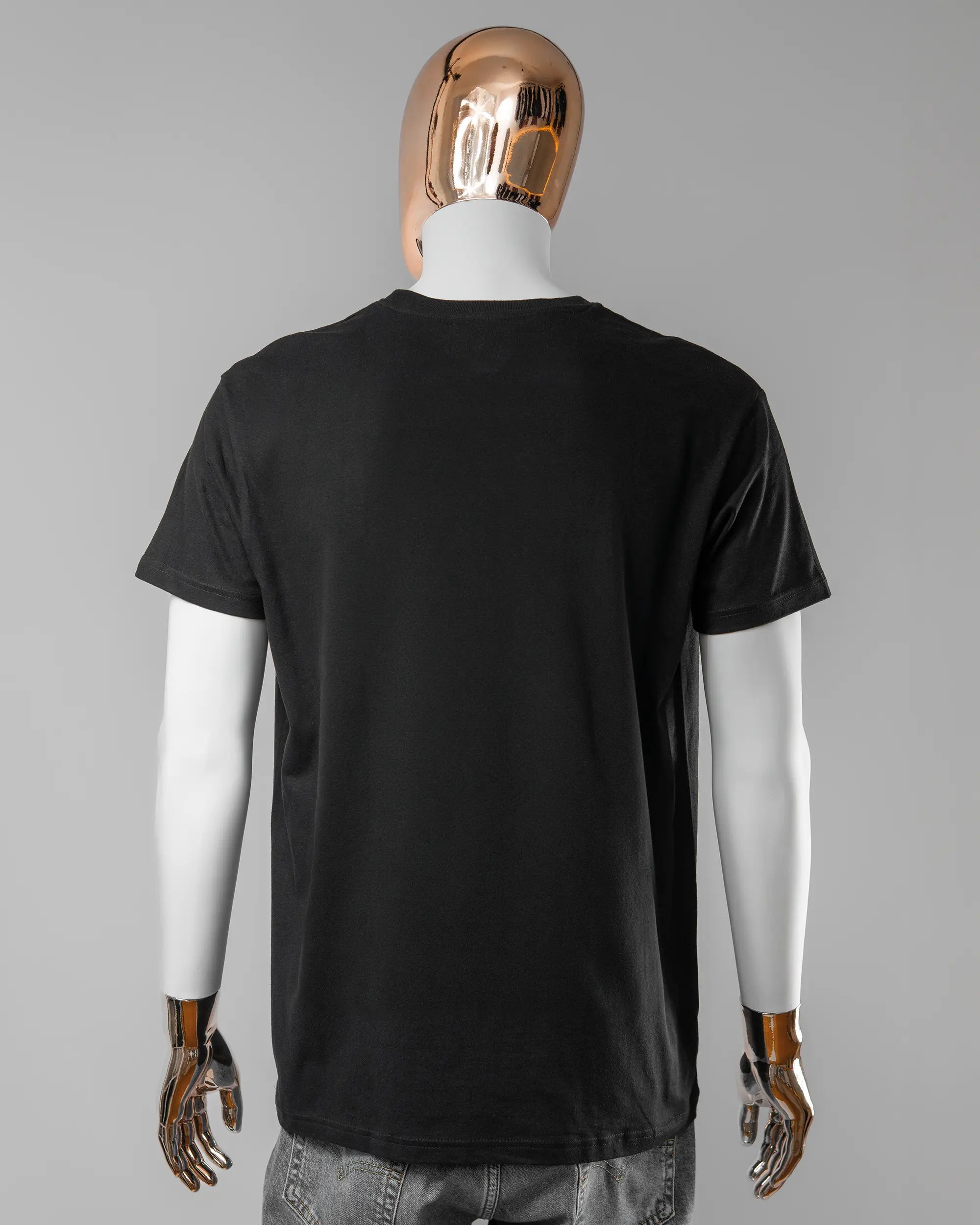 Rückseite des Basic Unisex T-Shirt Soft von Maondo ohne Motiv in der Farbe Black und in der Größe L getragen von einer maskulinen Puppe