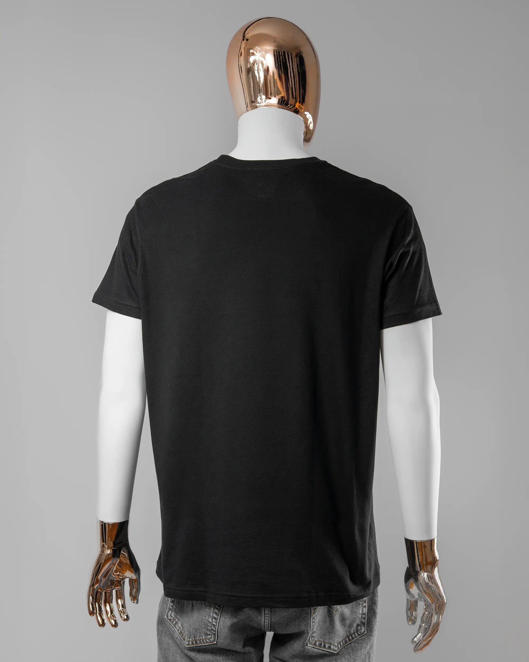 Rückseite des Basic Unisex T-Shirt Soft von Maondo ohne Motiv in der Farbe Black und in der Größe L getragen von einer maskulinen Puppe